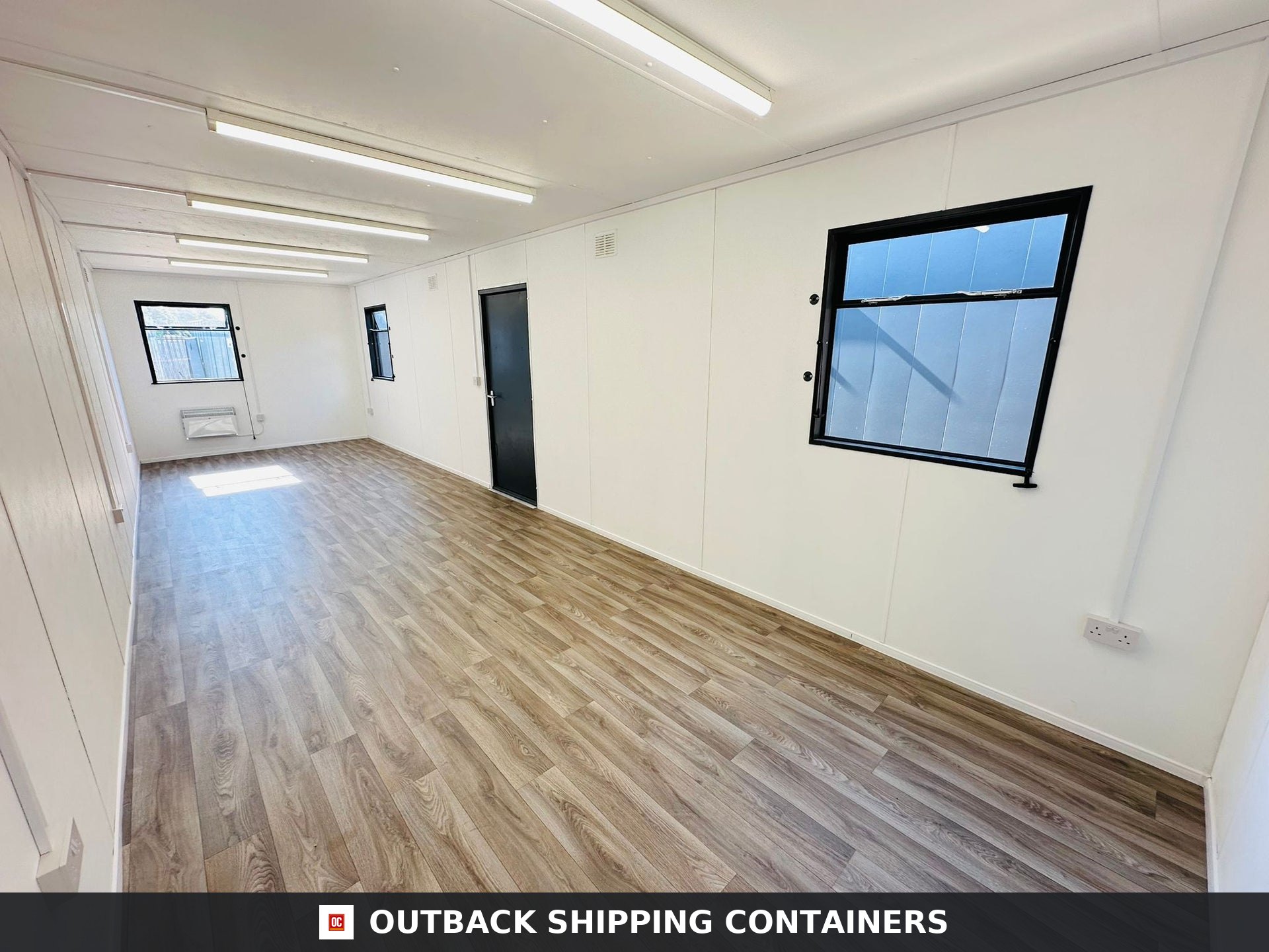 32x10ft Cabin for Sale — Roof and Structural Detail | Outback Shipping Containers 2 3 Interior view of an open plan 32x10ft office cabin showing wood effect flooring and white walls