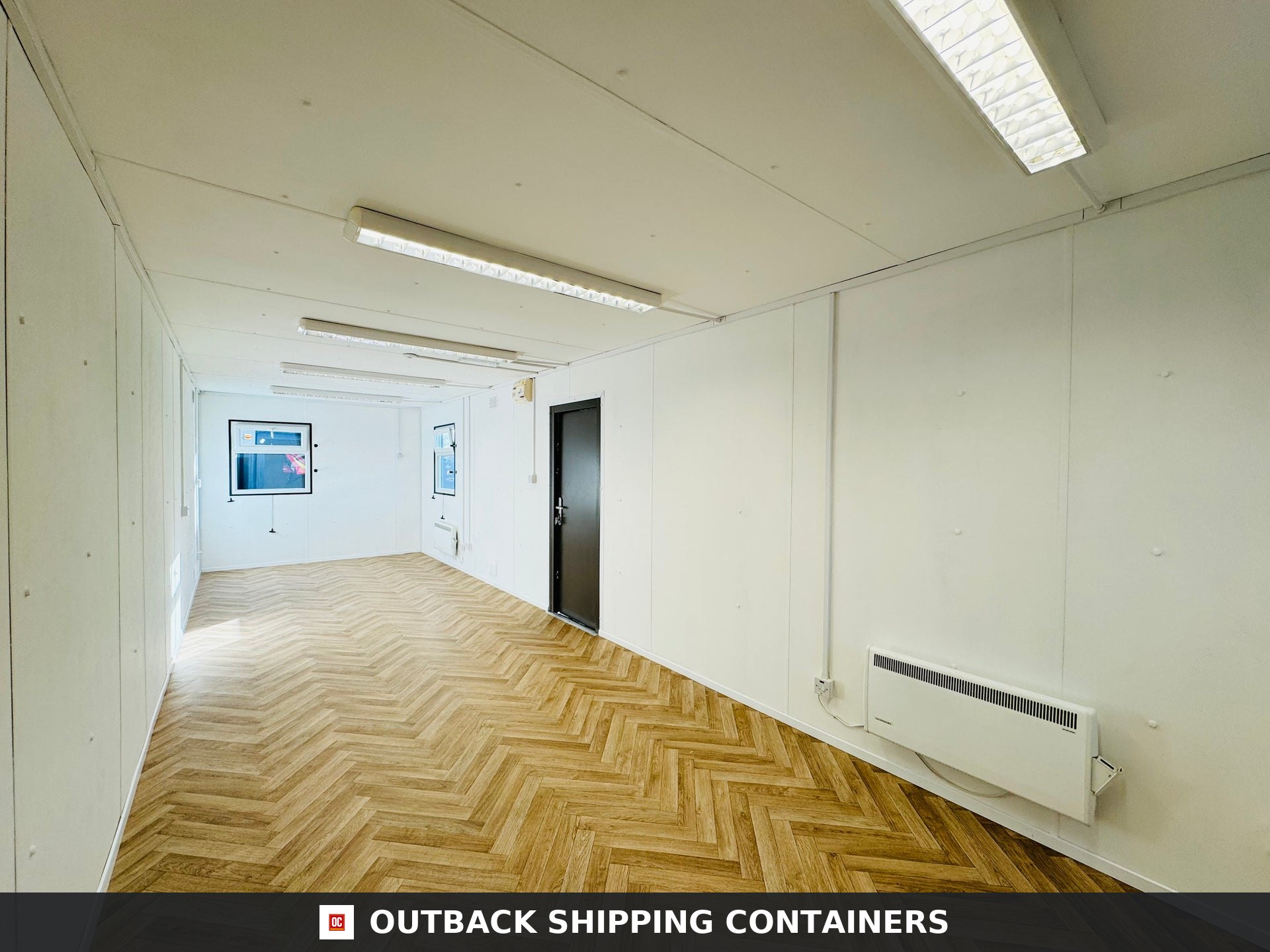32ft Cabin for Sale — Interior Detail | Outback Shipping Containers 2 Interior view of a 32ft refurbished shipping container office with white walls and herringbone wood floors