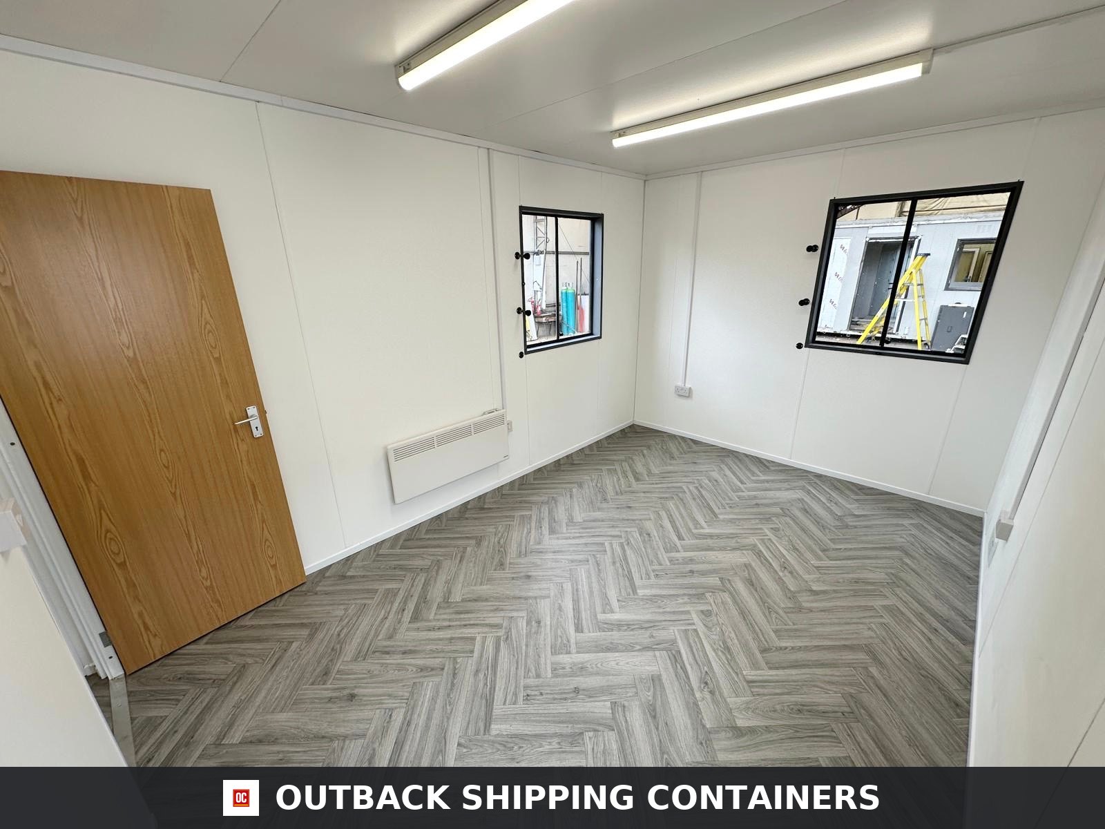 32x10Ft for Sale — Three-Quarter Angle View | Outback Shipping Containers Refurbished office cabin interior featuring a kitchenette with black sink and wood effect countertop on vinyl flooring