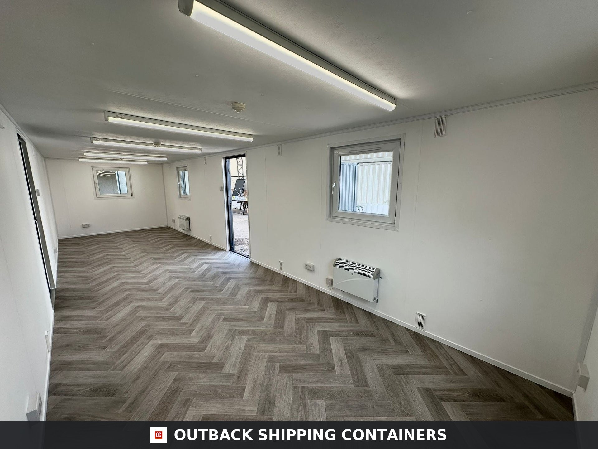 32x10ft Cabin for Sale — Corner Casting and Frame Detail | Outback Shipping Containers 2 Interior of a refurbished 32x10 shipping container office featuring herringbone flooring and white walls