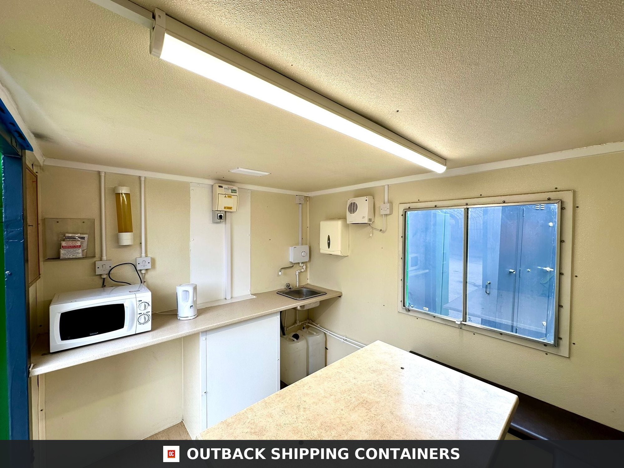 Groundhog Towable Mobile Welfare | Towable Canteen + Toilet — Three-Quarter Angle View Interior of a refurbished Groundhog GP 360 mobile welfare unit showing a kitchenette with microwave and sink