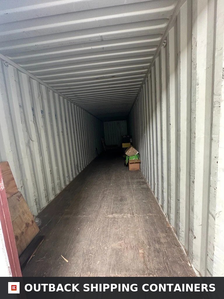 Interior view of a 40ft high cube shipping container with corrugated steel walls and plywood flooring