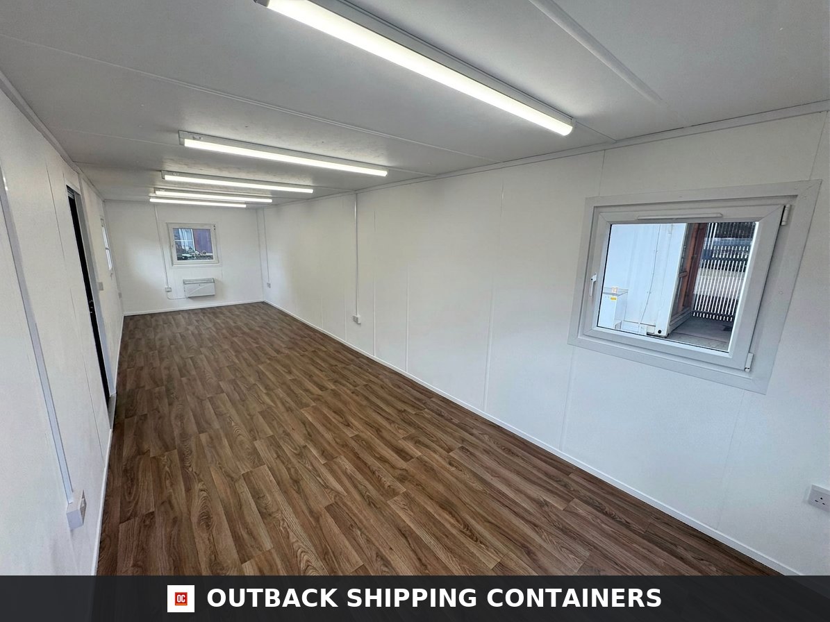 32ft Cabin for Sale — Side Profile View | Outback Shipping Containers Interior of a refurbished 32ft open plan portable office cabin with wood vinyl flooring and white walls