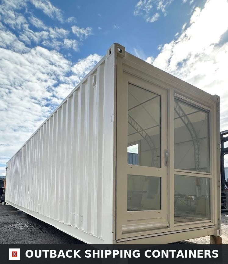 White 40ft converted shipping container office with large glass doors and windows under a blue sky
