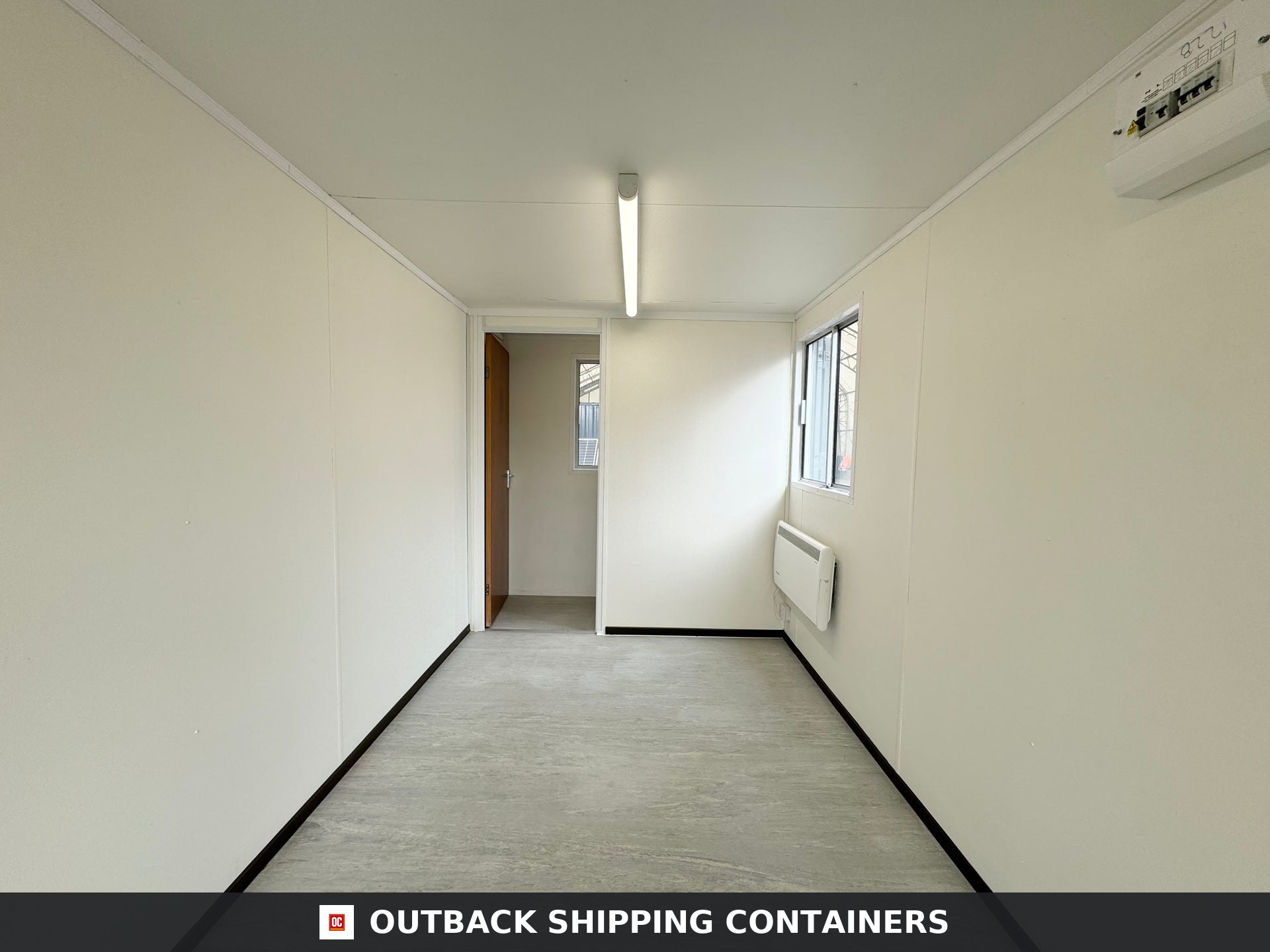 21x8ft for Sale — Interior View | Outback Shipping Containers 2 Interior view of a 21ft shipping container office with white walls, grey flooring, and a single light fixture