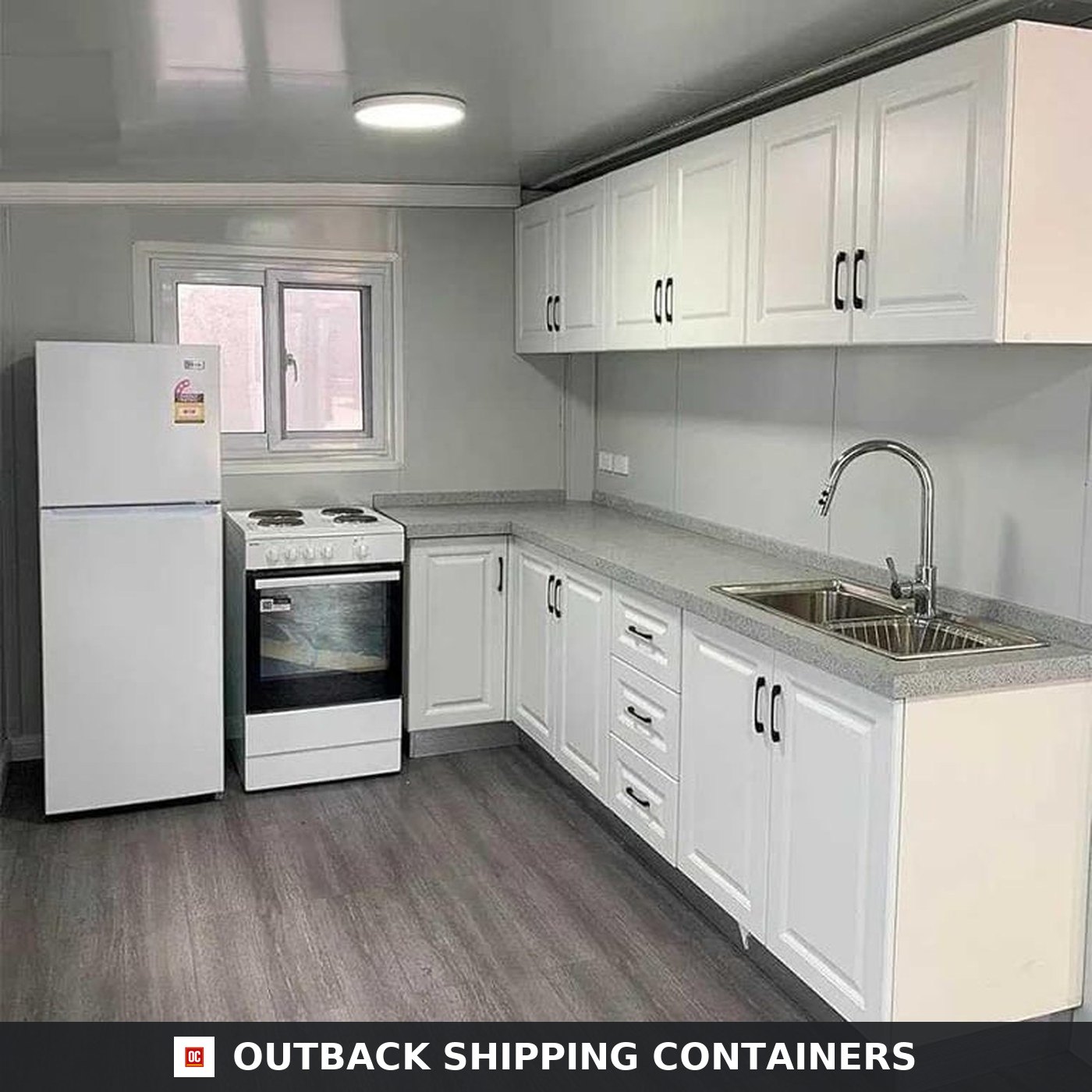 40ft Luxury 3 Bedroom Foldable Container Home for Sale — White Kitchen with Full Appliance Package | Outback Shipping Containers White shaker kitchen inside the 40ft foldable container home with electric range, refrigerator, stainless sink and stone-look benchtop