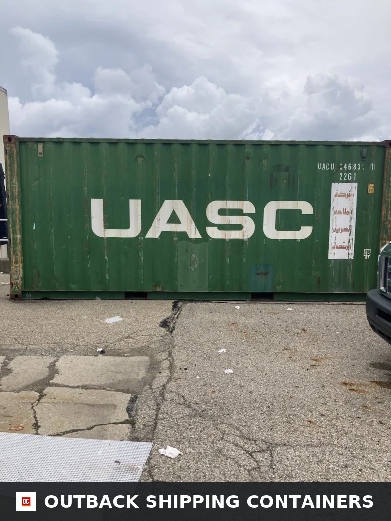 Green 20ft UASC shipping container side view on a concrete lot showing white logo and serial markings
