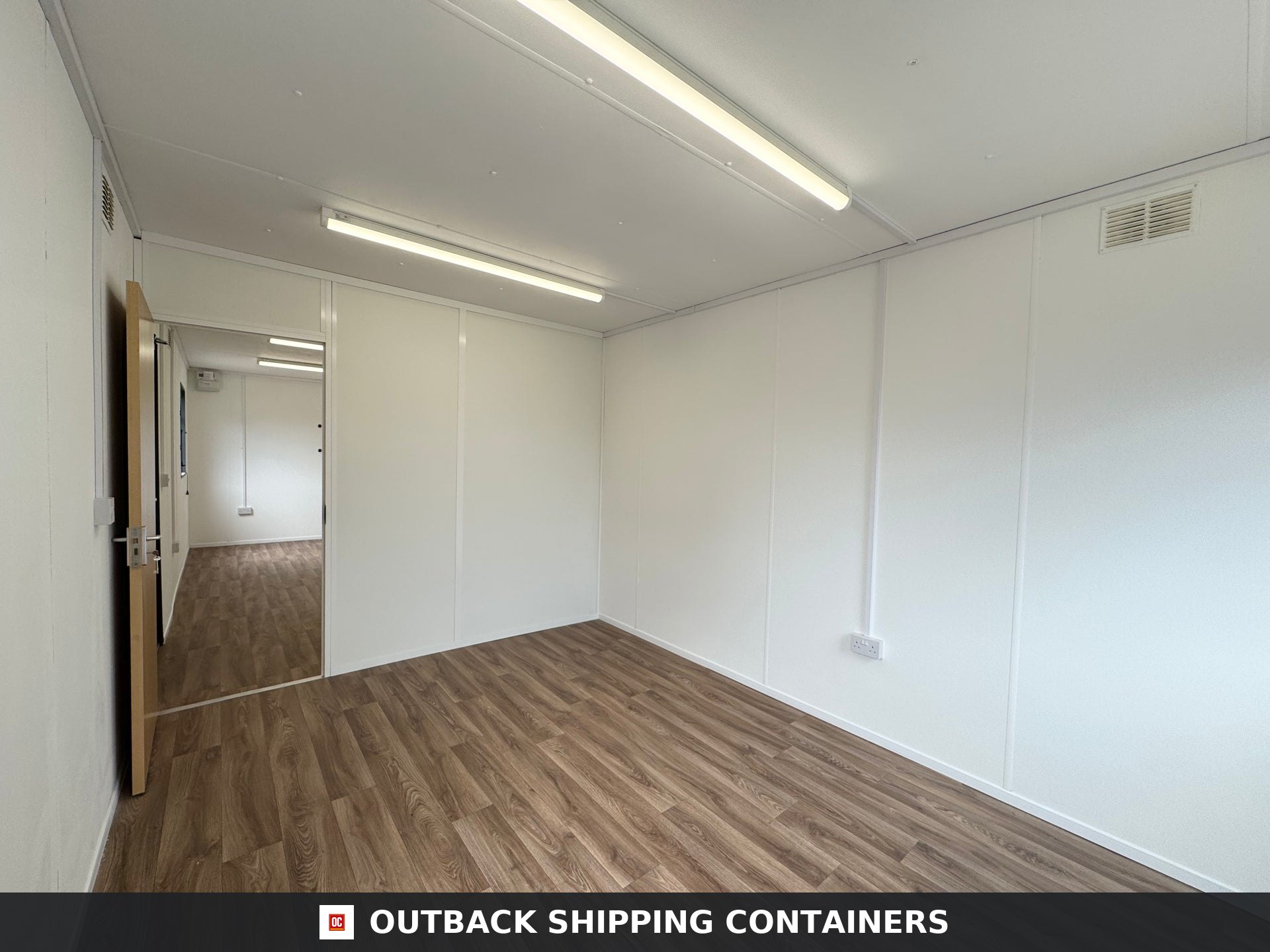 32x10 ft 32x10FT for Sale — Interior Detail | Outback Shipping Containers Interior view of a 32x10 refurbished portable cabin showing white walls, wood-style flooring, and LED lighting