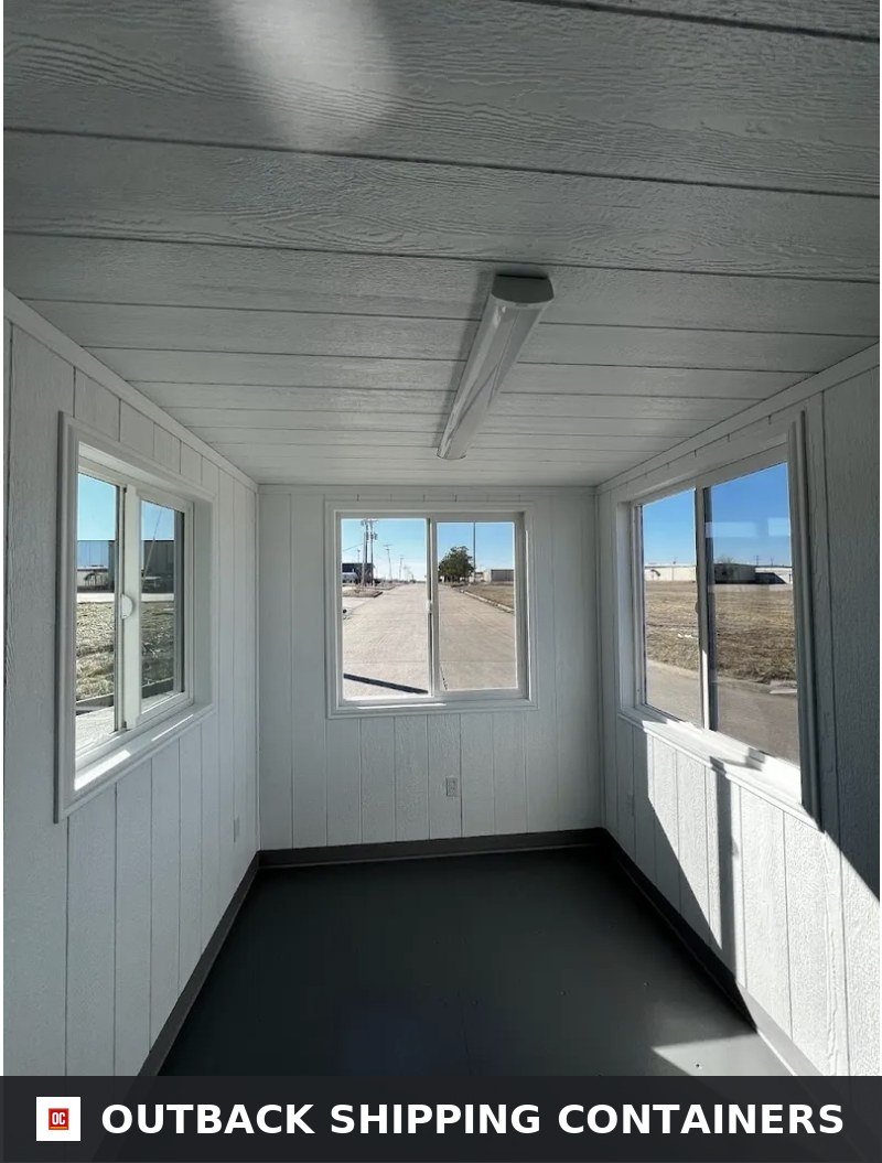 20ft mobile office interior with white paneled walls and three large sliding windows
