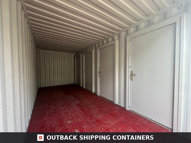 Interior view of a 20ft shipping container with partitioned storage units featuring four individual white doors