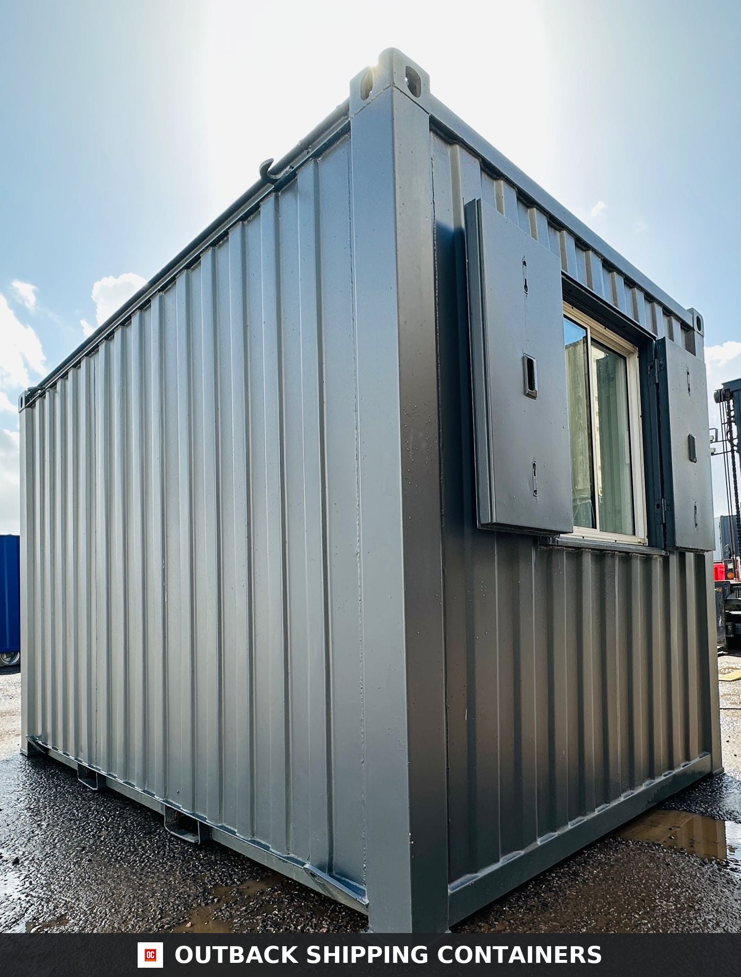 12x8 ft 12x8FT for Sale — Interior Detail | Outback Shipping Containers Interior view of a 12x8 portable office container featuring white walls, a sliding window, and dark herringbone flooring