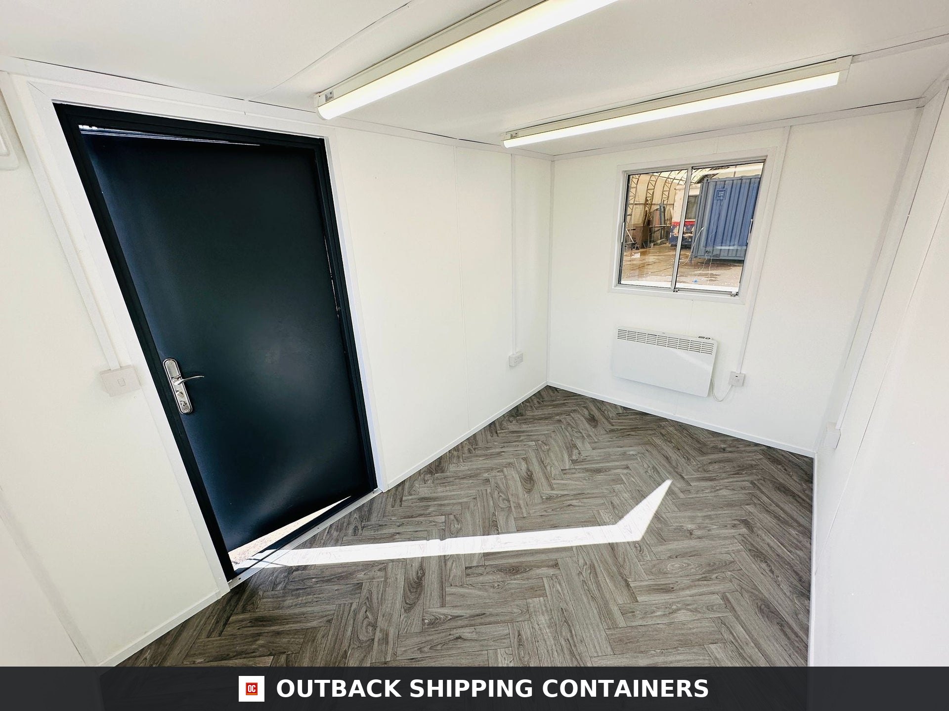 12x8 ft 12x8FT for Sale — Side Profile View | Outback Shipping Containers 12x8 portable office interior with white walls grey herringbone flooring black steel door and overhead lights