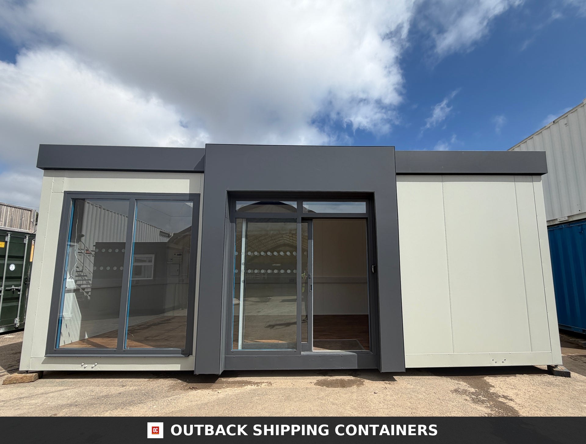 26x12ft for Sale — Door and Entry Detail | Outback Shipping Containers Modern 26x12 grey and white marketing suite with large glass sliding doors and full-height windows outdoors