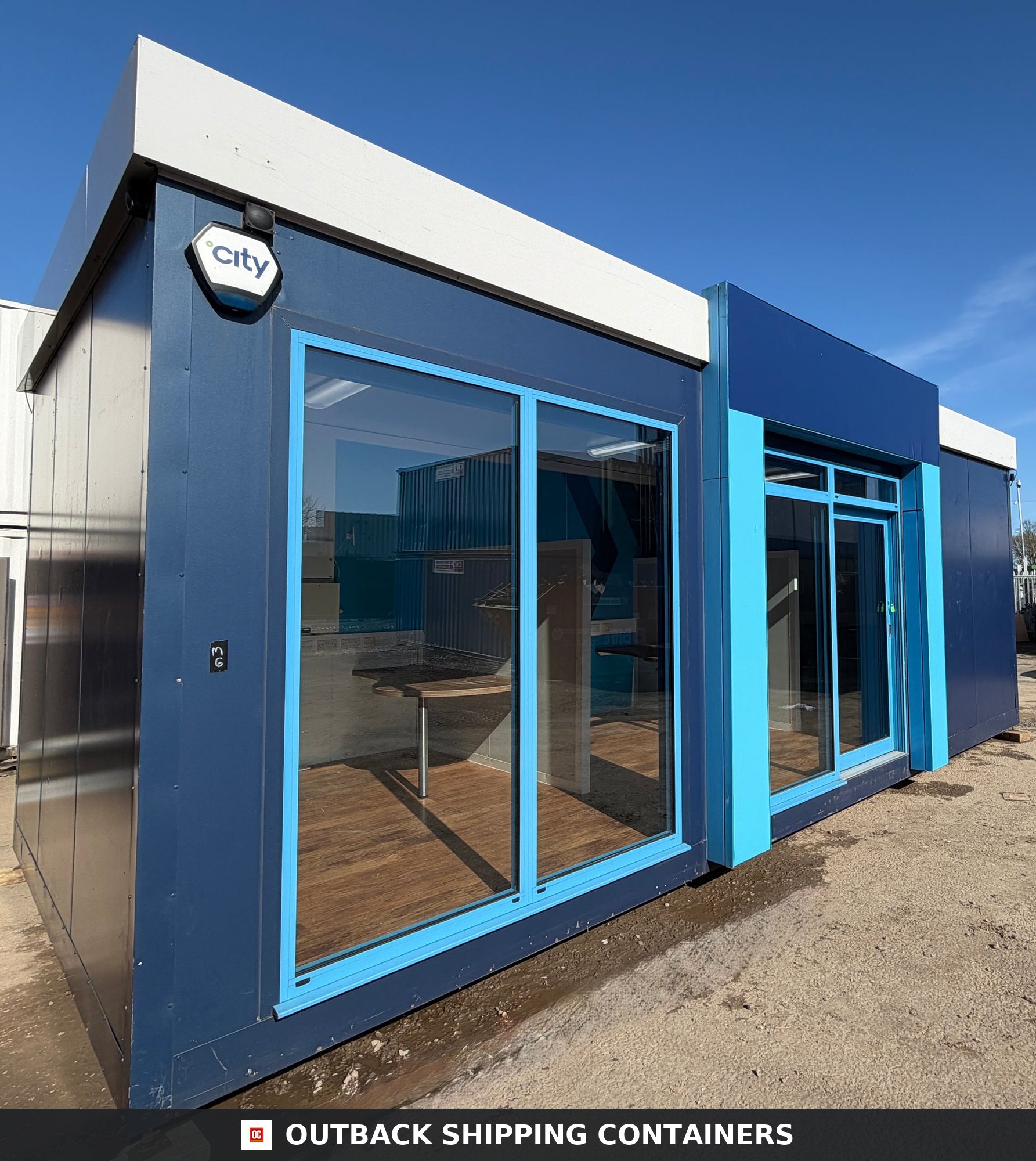 26x12ft for Sale — Door and Entry Detail | Outback Shipping Containers Interior of a refurbished 26x12 ft portable marketing suite showing office cubicles with desks and blue accent walls