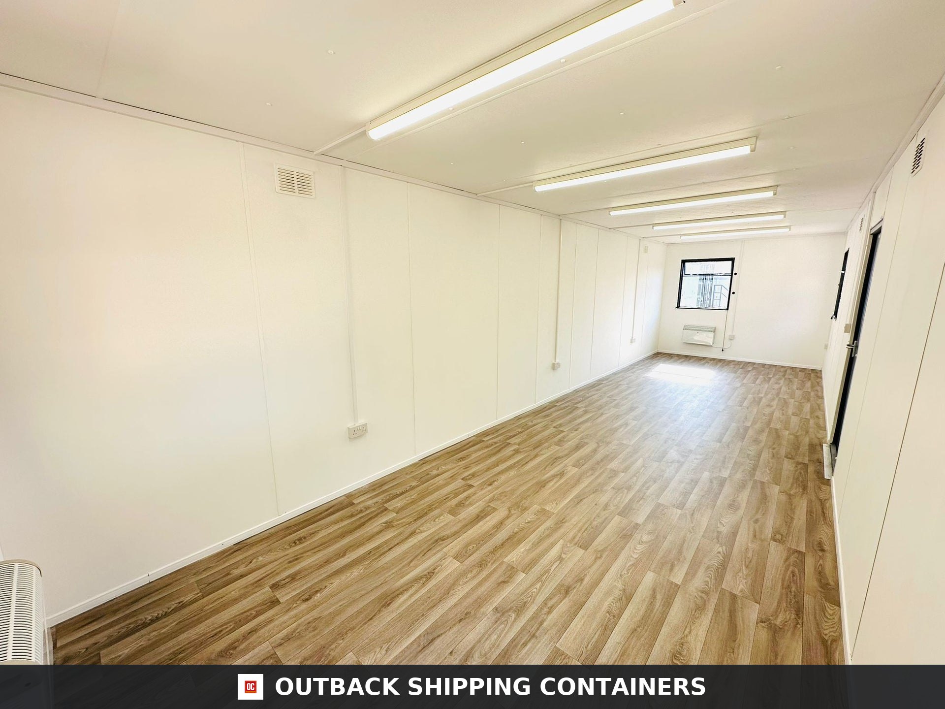 32x10ft Cabin for Sale — Door and Entry Detail | Outback Shipping Containers 2 3 Refurbished 32x10 open plan site office interior with wood flooring white walls and fluorescent lighting