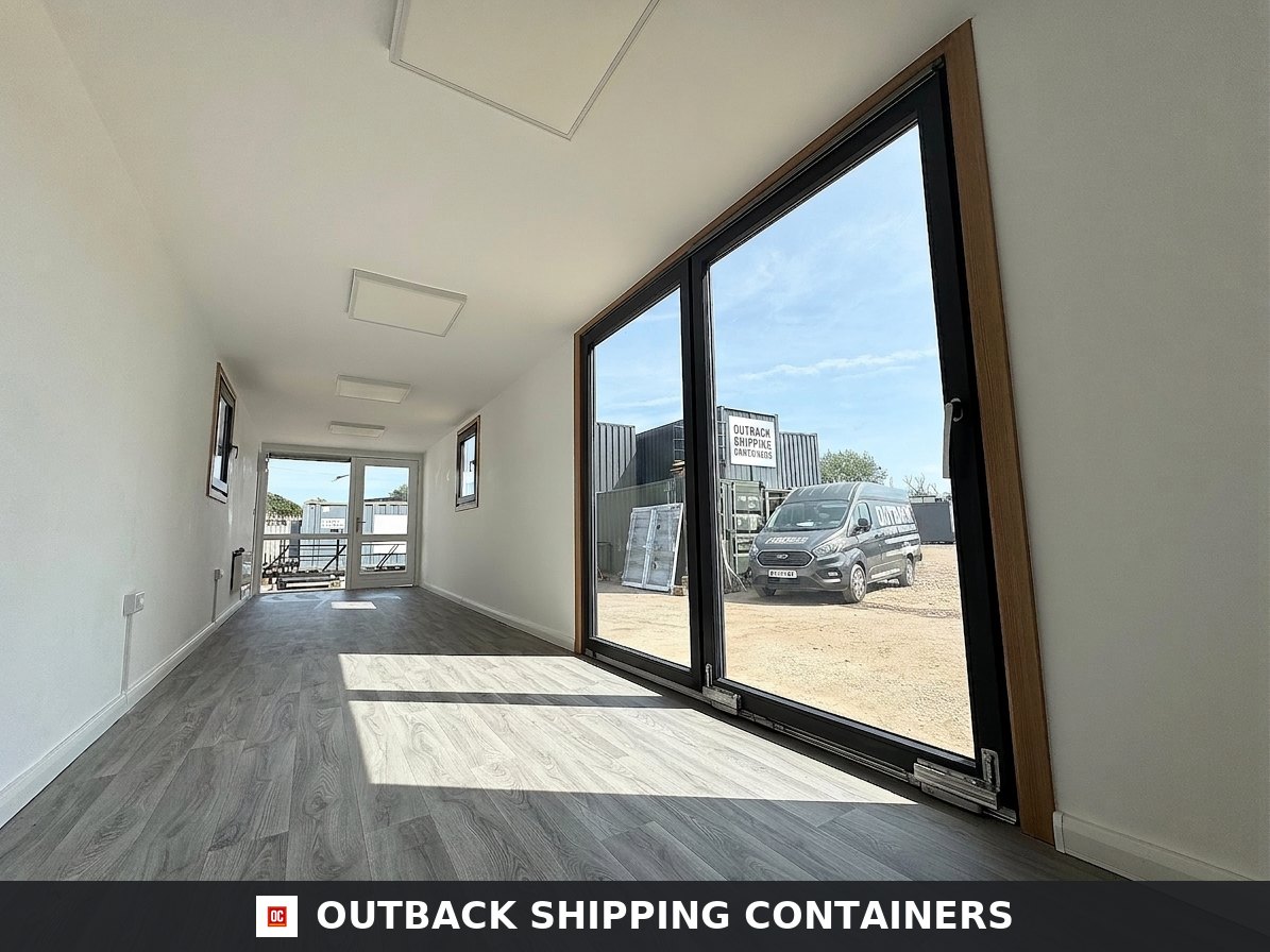 40ft shipping container office interior with wood floors and large glass sliding doors