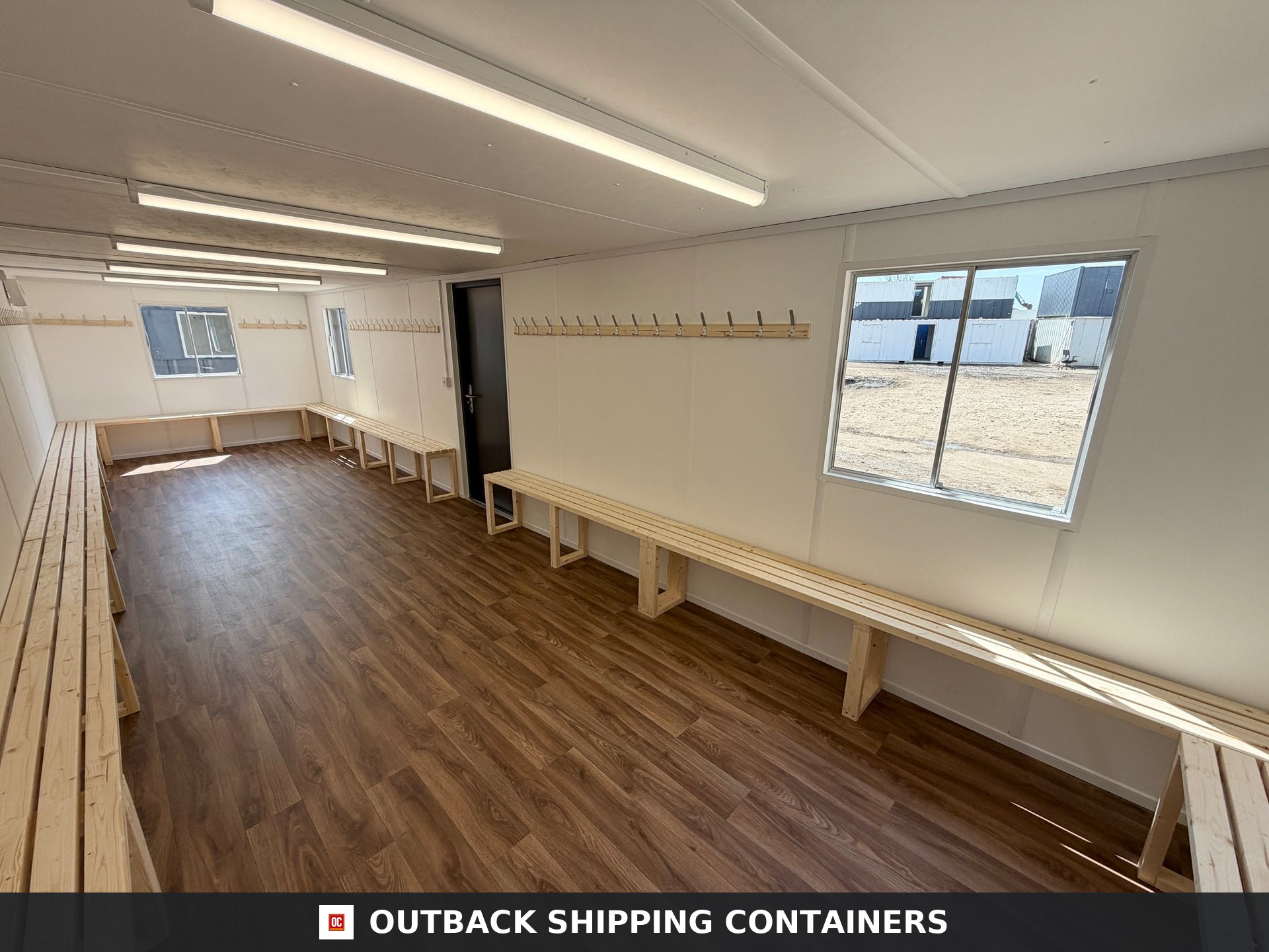 32x10ft Cabin for Sale — Roof and Structural Detail | Outback Shipping Containers 2 3 4 Interior view of a 32x10ft container changing room featuring wood benches, coat hooks, and vinyl flooring