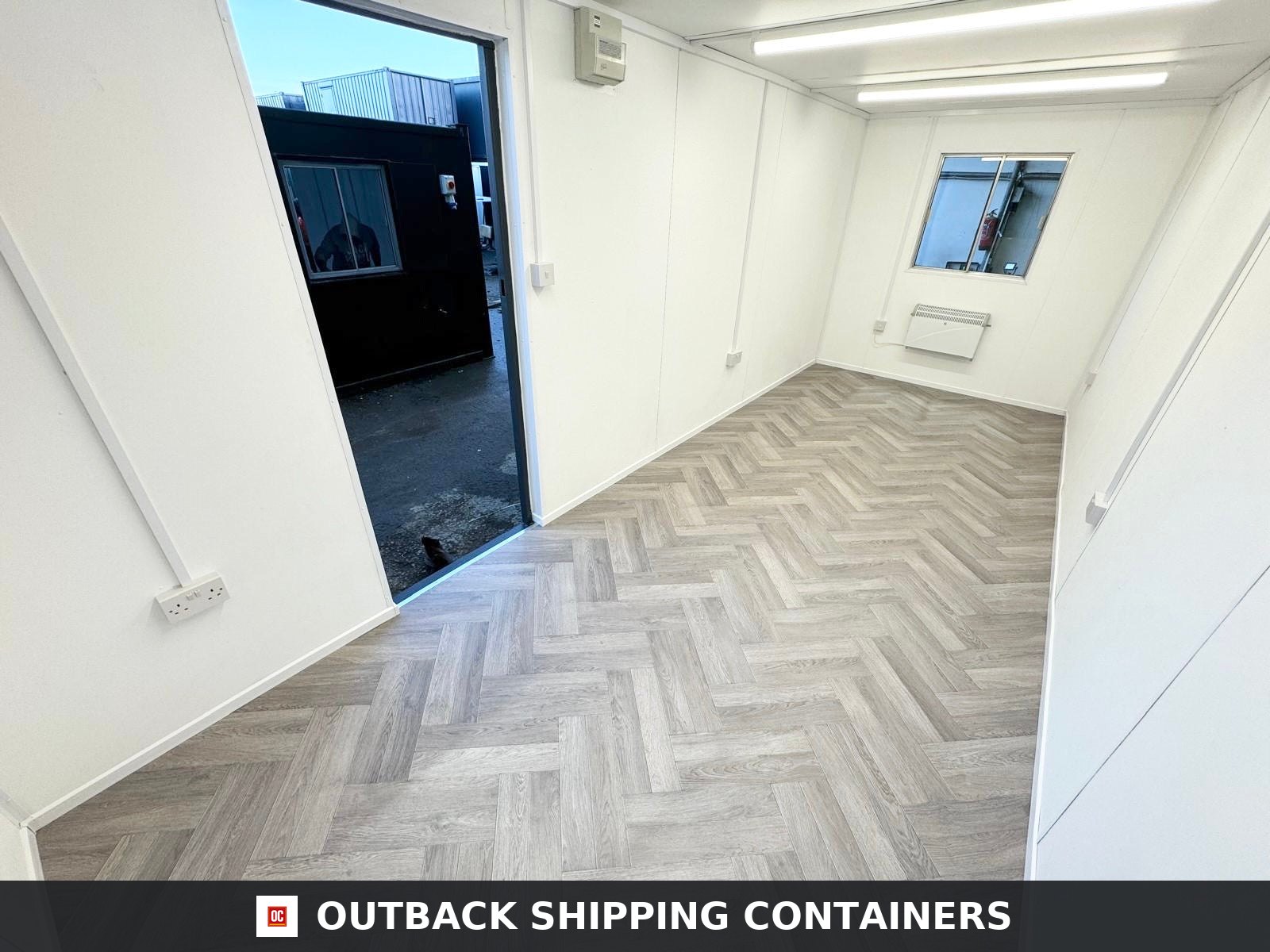 20x8ft for Sale — Interior View | Outback Shipping Containers 20x8ft refurbished portable office cabin in dark gray with a dual pane window and heavy duty exterior security shutters