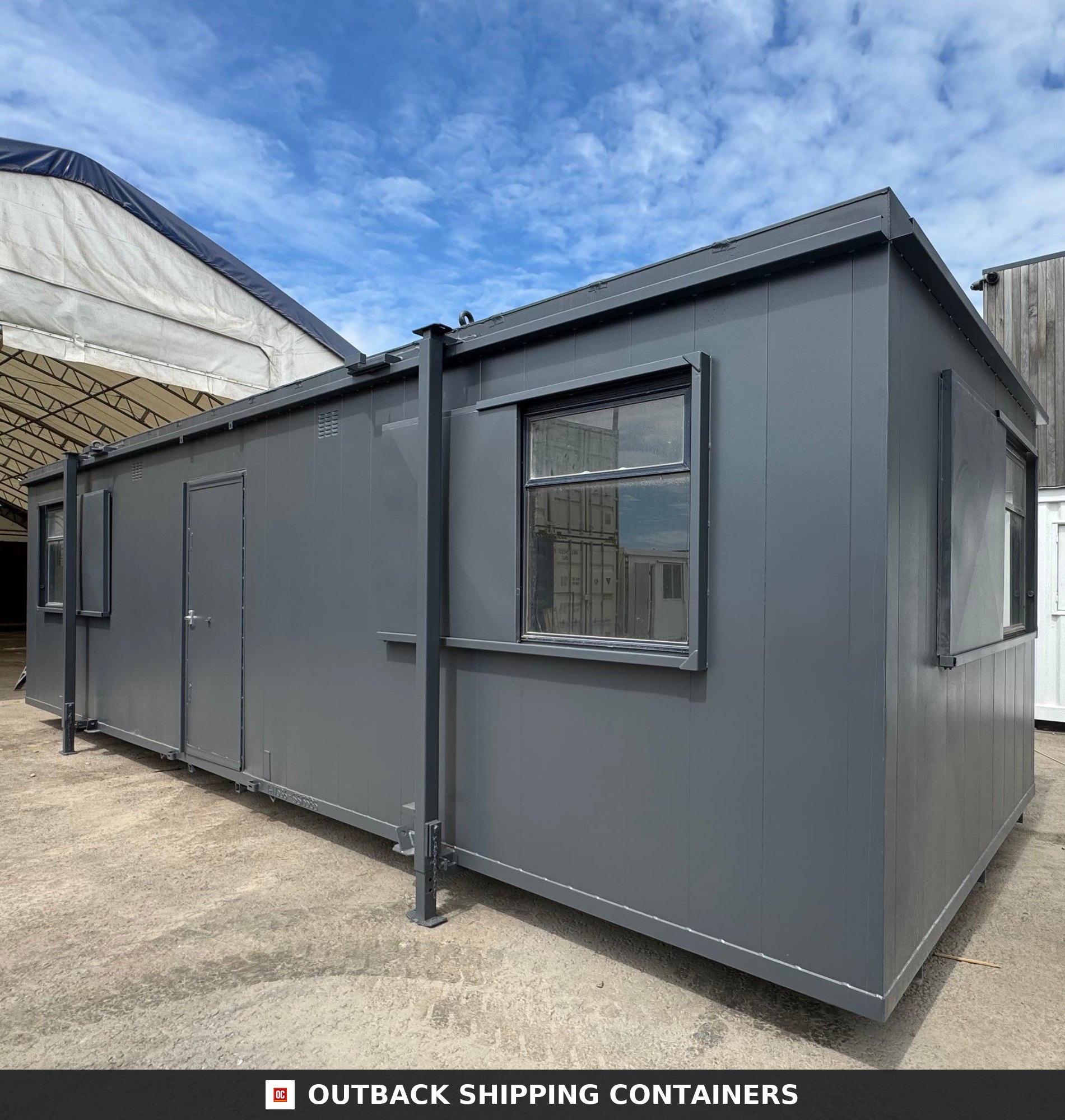 32x10 ft 32x10FT for Sale — Interior View | Outback Shipping Containers Charcoal gray 32x10 anti-vandal portable cabin with steel security shutters and a matching pedestrian door