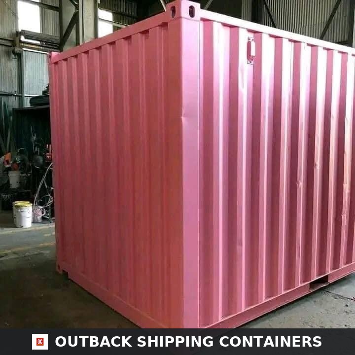 10ft pink shipping container with corrugated steel walls sitting inside a manufacturing warehouse