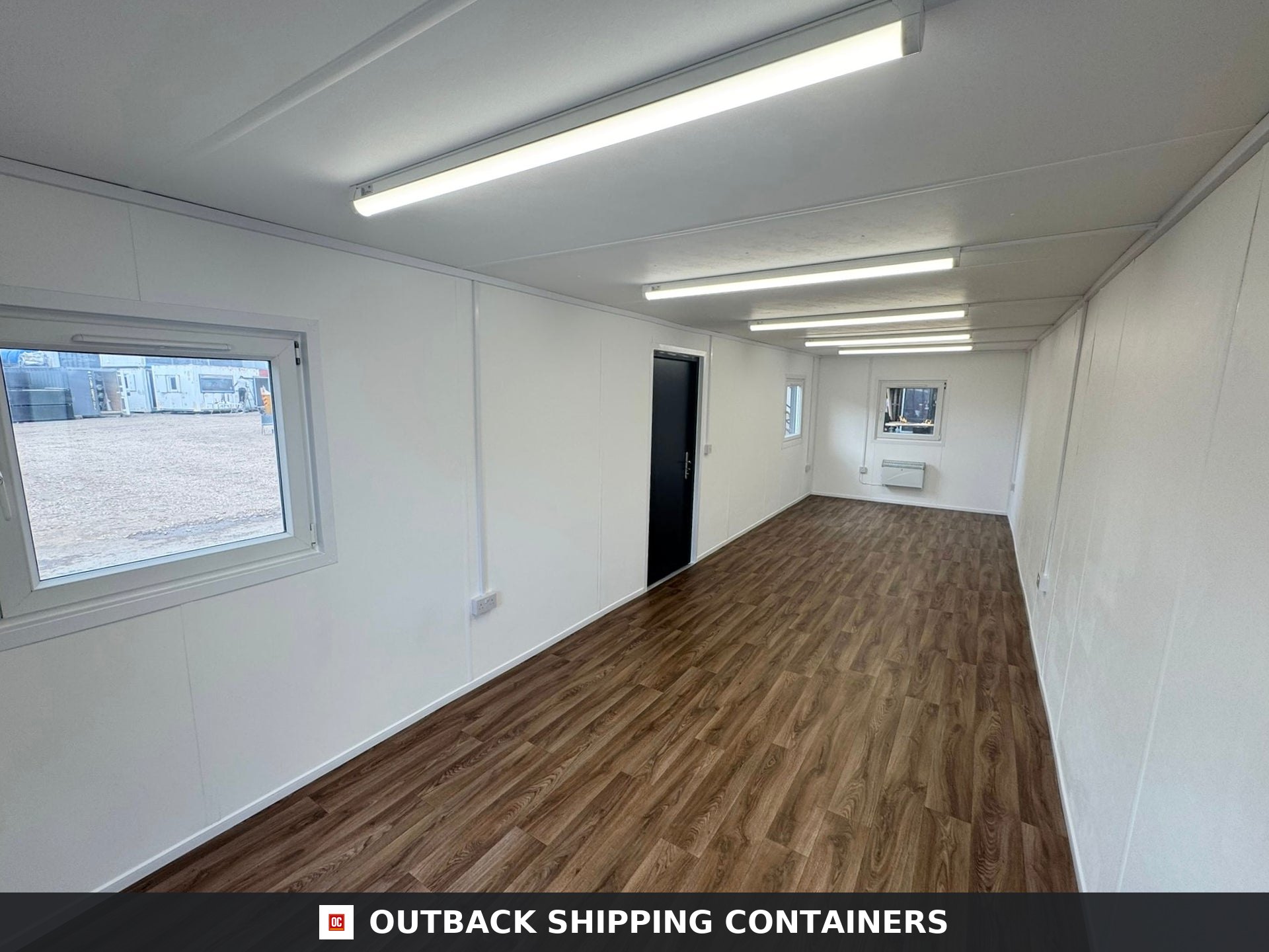 32ft Cabin for Sale — Corner Casting and Frame Detail | Outback Shipping Containers Refurbished 32ft anti-vandal cabin interior view with wood laminate flooring white walls and fluorescent ceiling lights