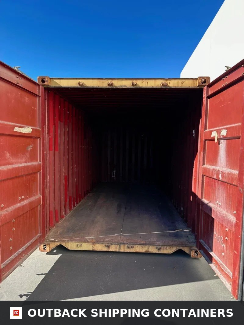 Used 20ft Conex Shipping / Storage Container – Yellow/Gold for Sale — Door and Entry Detail Interior view of an open 20ft conex shipping container with red metal walls and a dark wood floor