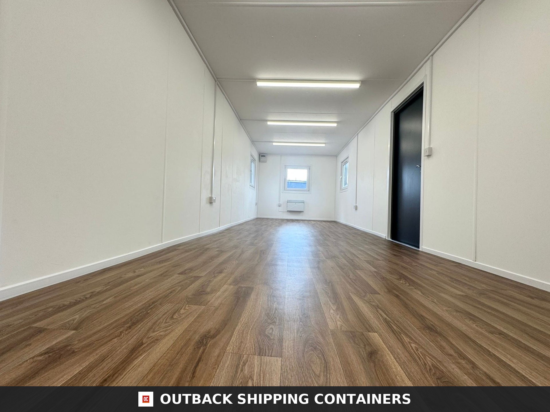32ft Cabin for Sale — Window and Shutter Detail | Outback Shipping Containers Interior view of a 32ft anti-vandal portable building with wood-effect flooring and white walls