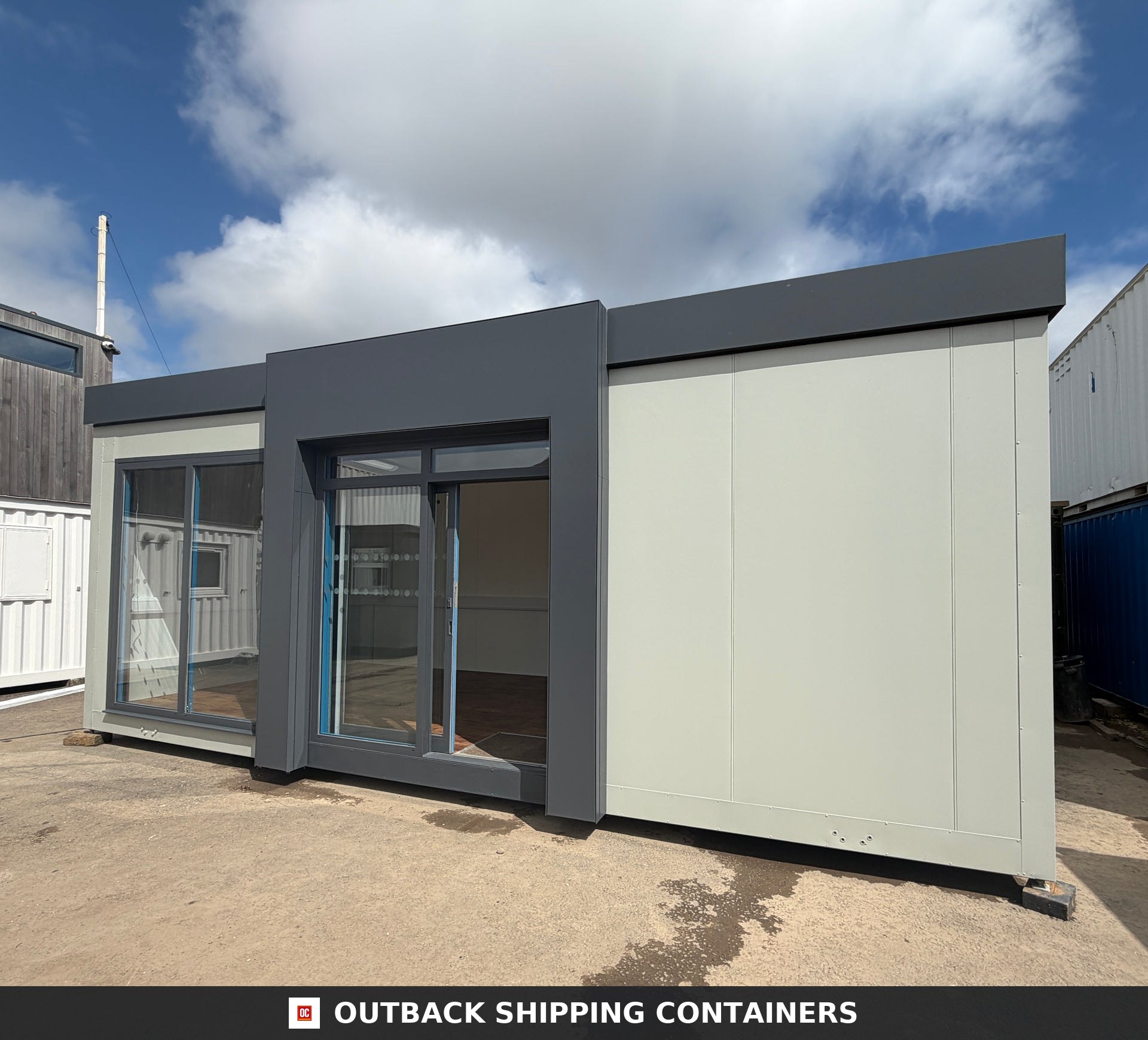 26x12ft for Sale — Three-Quarter Angle View | Outback Shipping Containers 26 by 12 foot marketing suite portable building with glass sliding doors and gray trim details