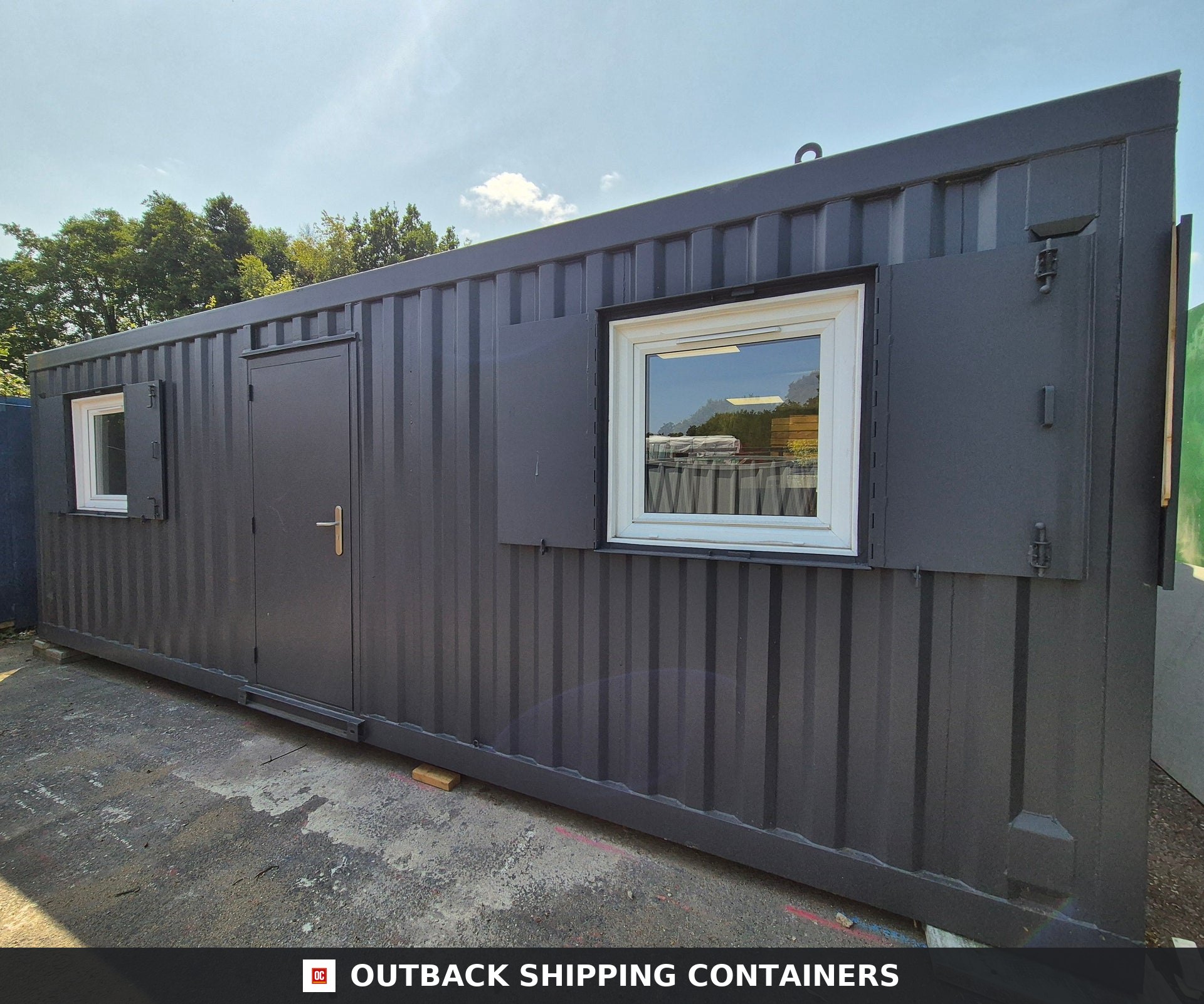 Modular Building 2 Bay 24x20FT — Three-Quarter Angle View | Outback Shipping Containers Exterior view of a dark grey refurbished 24x20ft modular container building with two white-framed windows and a lockable door