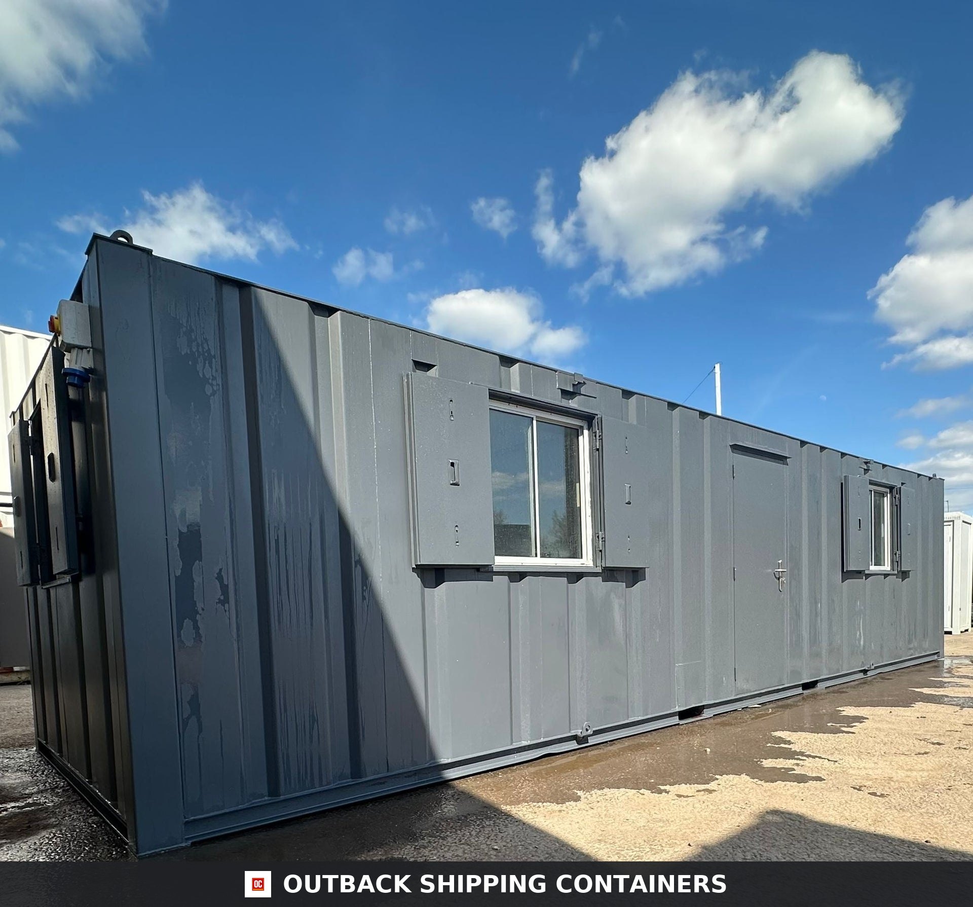 32ft Cabin for Sale — Window and Shutter Detail | Outback Shipping Containers 2 3 Refurbished 32ft anti-vandal portable cabin in grey with steel shutters and secure personnel door