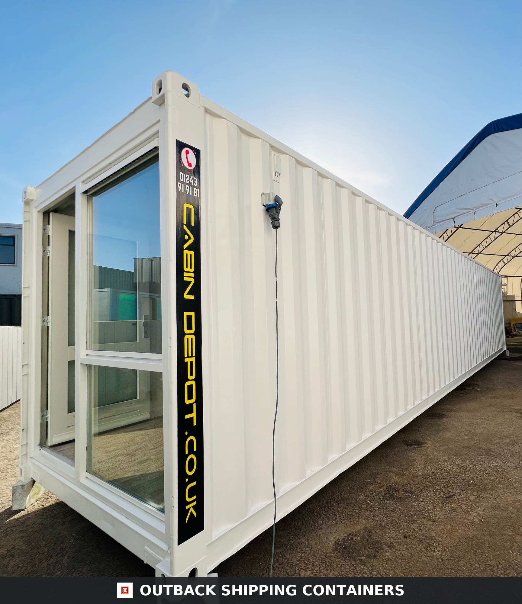 Exterior view of a white 40ft converted shipping container office with large glass windows and an electrical inlet