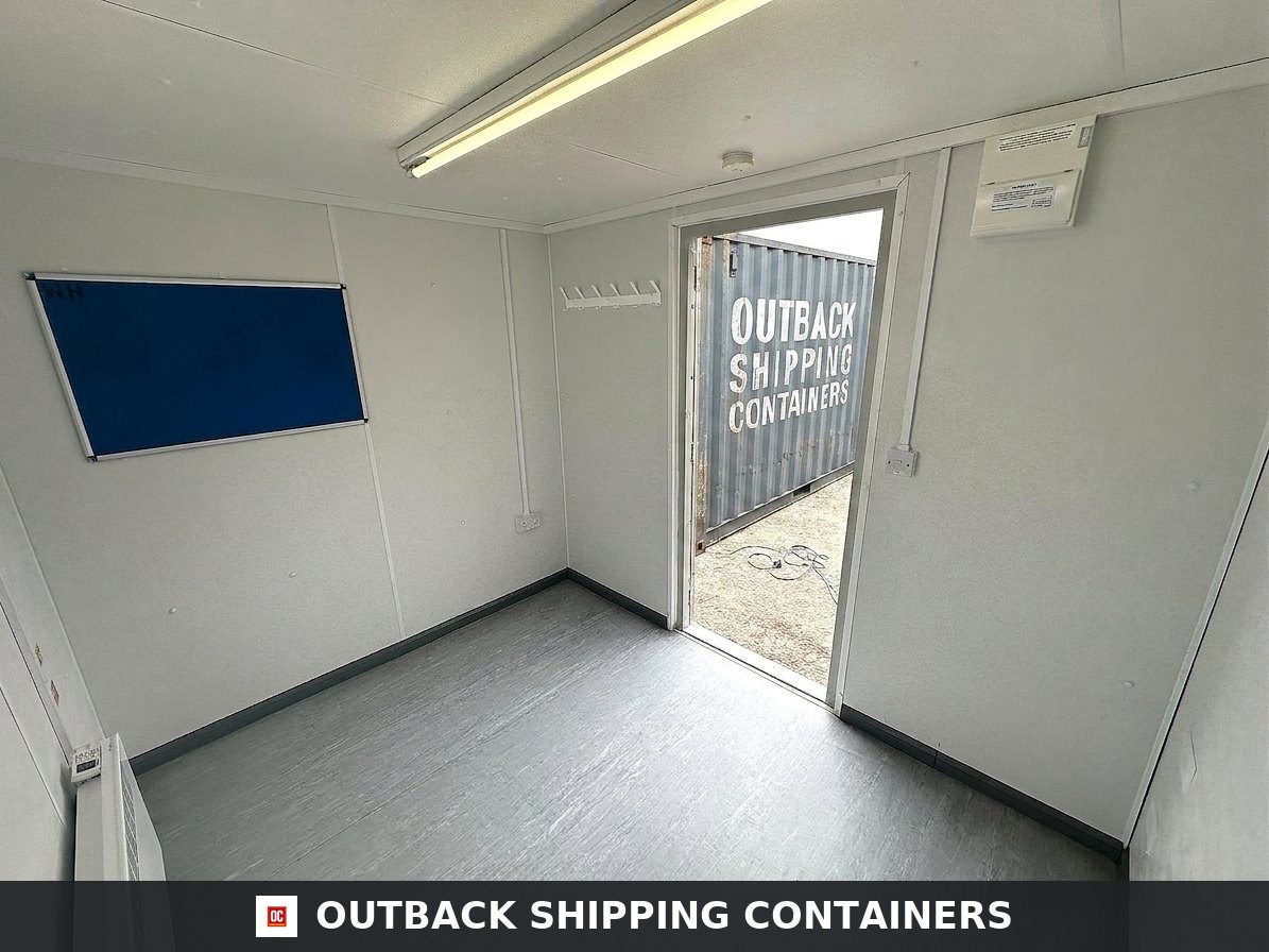 10x8 ft 10X8FT for Sale — Window and Shutter Detail | Outback Shipping Containers Interior view of a 10x8 portable office building showing white walls, grey flooring, a blue notice board, and open door