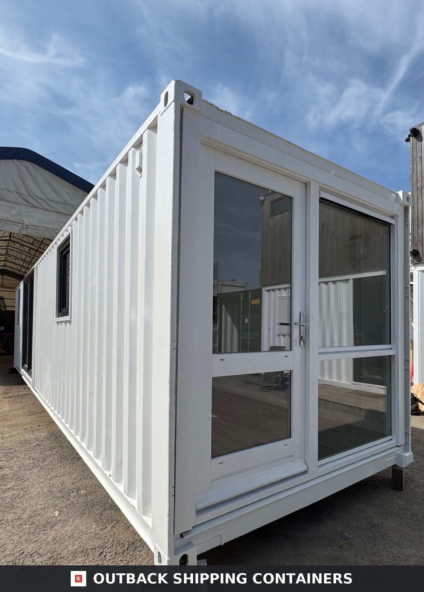 40ft white converted shipping container office with glass double doors and side window shown from an exterior angle