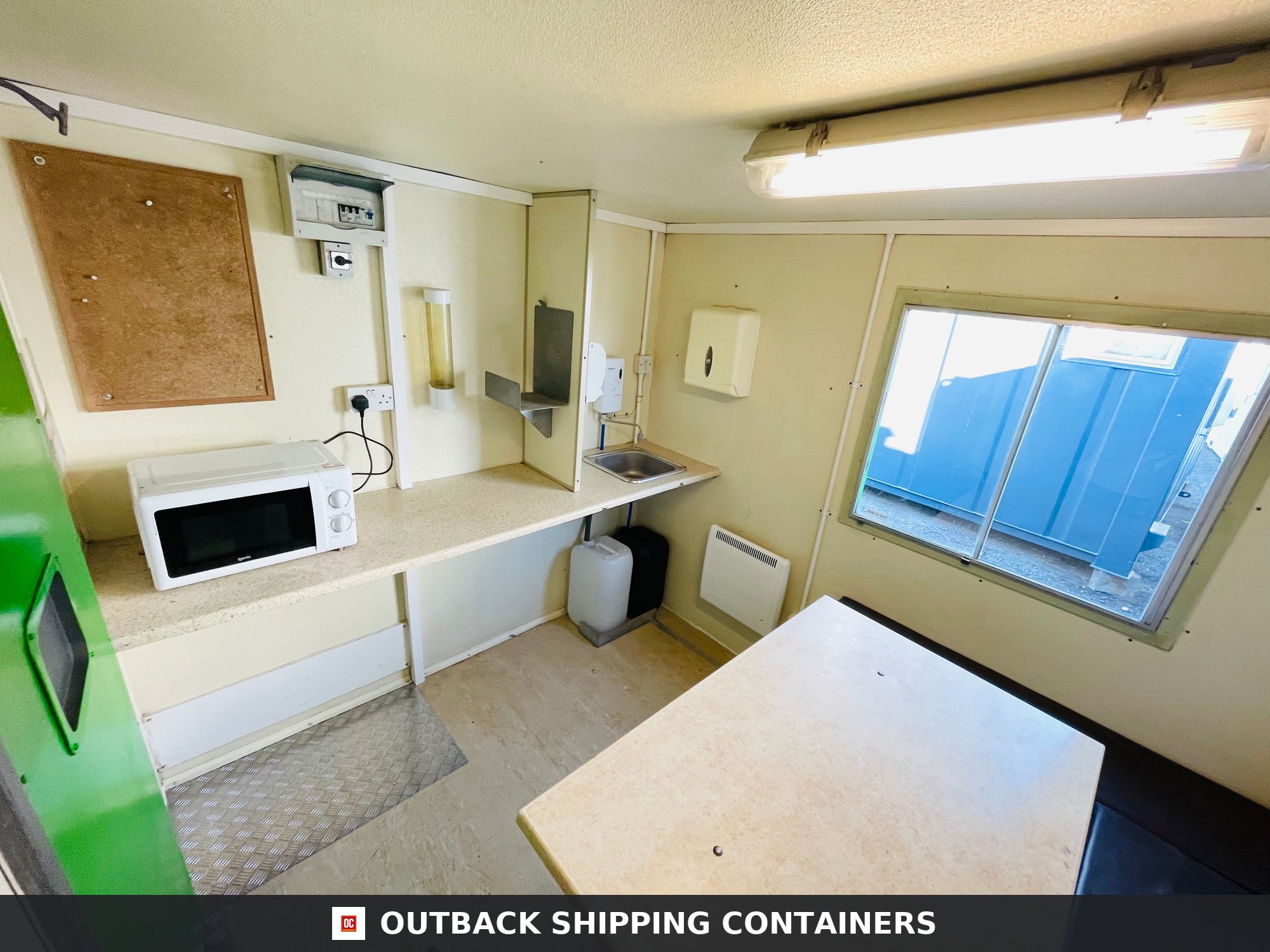 Towable Groundhog Mobile Welfare |Towable Canteen, Office, WC — Window and Shutter Detail Interior of a refurbished mobile welfare unit showing a microwave kitchenette sink and dining table area