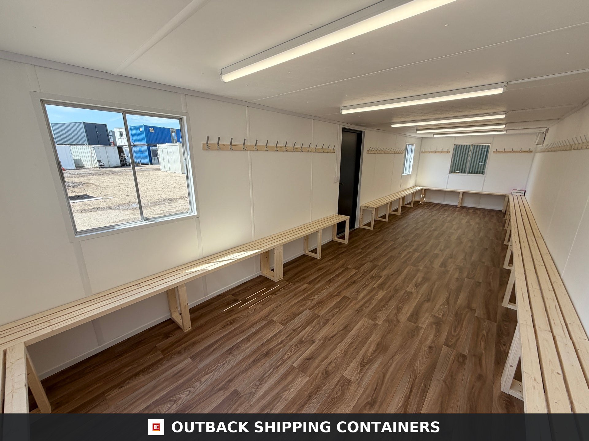 32x10ft Cabin for Sale — Window and Shutter Detail | Outback Shipping Containers 2 3 4 Refurbished 32x10ft container cabin storage room with wood slat benches and wall mounted coat hooks