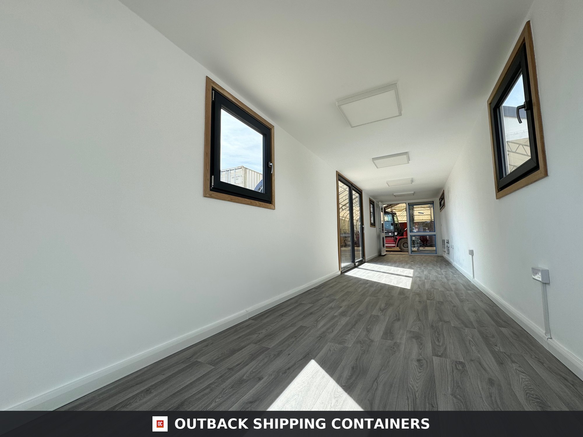 Interior view of a 40ft open plan container office featuring wood-style flooring and white finished walls