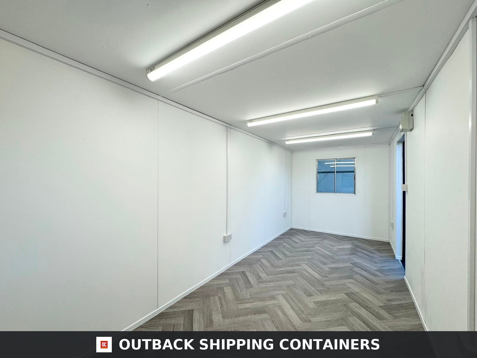 20x8ft for Sale — Interior Detail | Outback Shipping Containers Interior view of a 20ft container office with herringbone flooring, white paneled walls, and overhead LED strip lighting