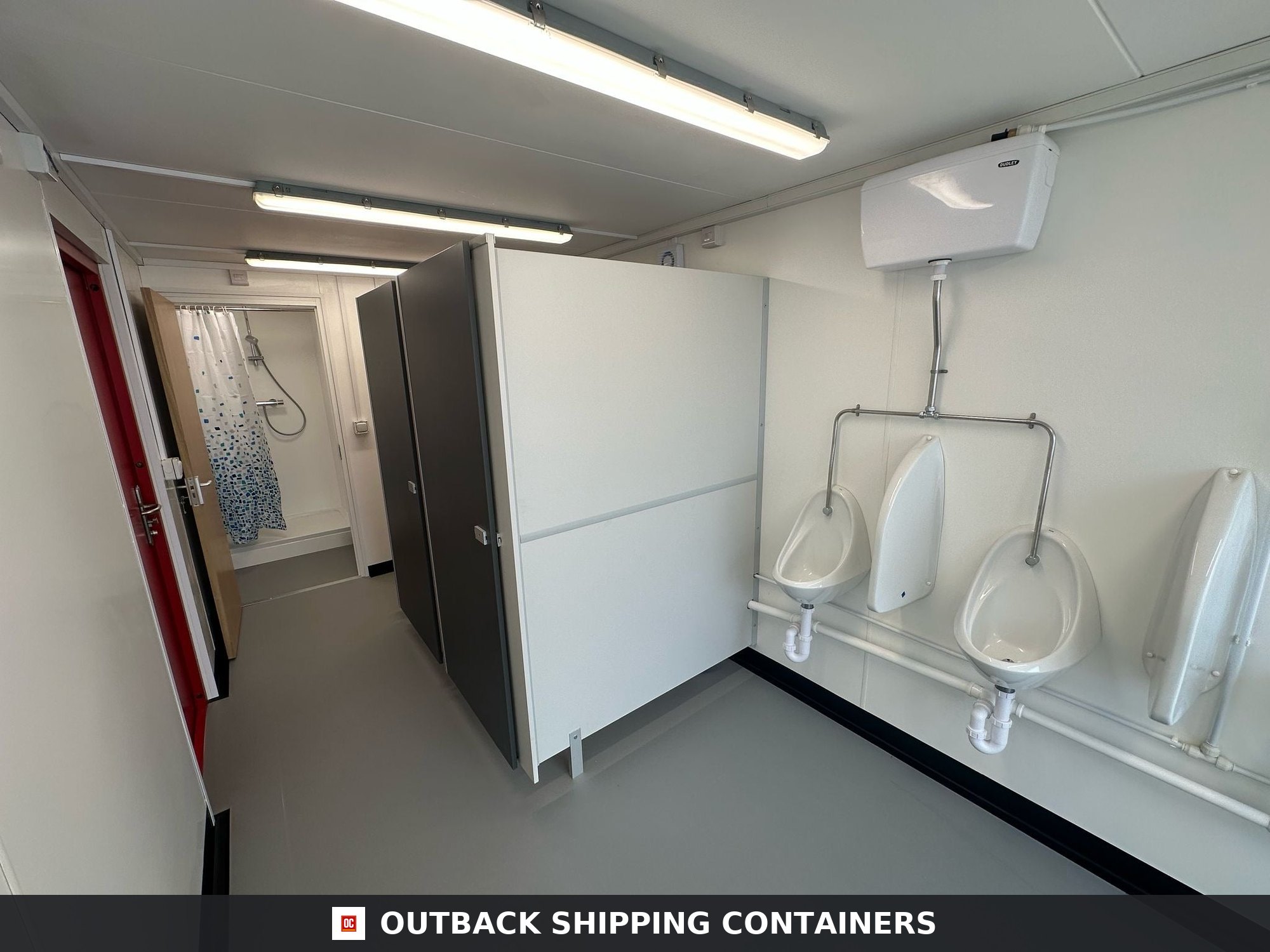 40x8ft for Sale — Side Profile View | Outback Shipping Containers 2 Interior view of a 40ft shipping container welfare unit with urinals, toilet stalls, and a shower cubicle