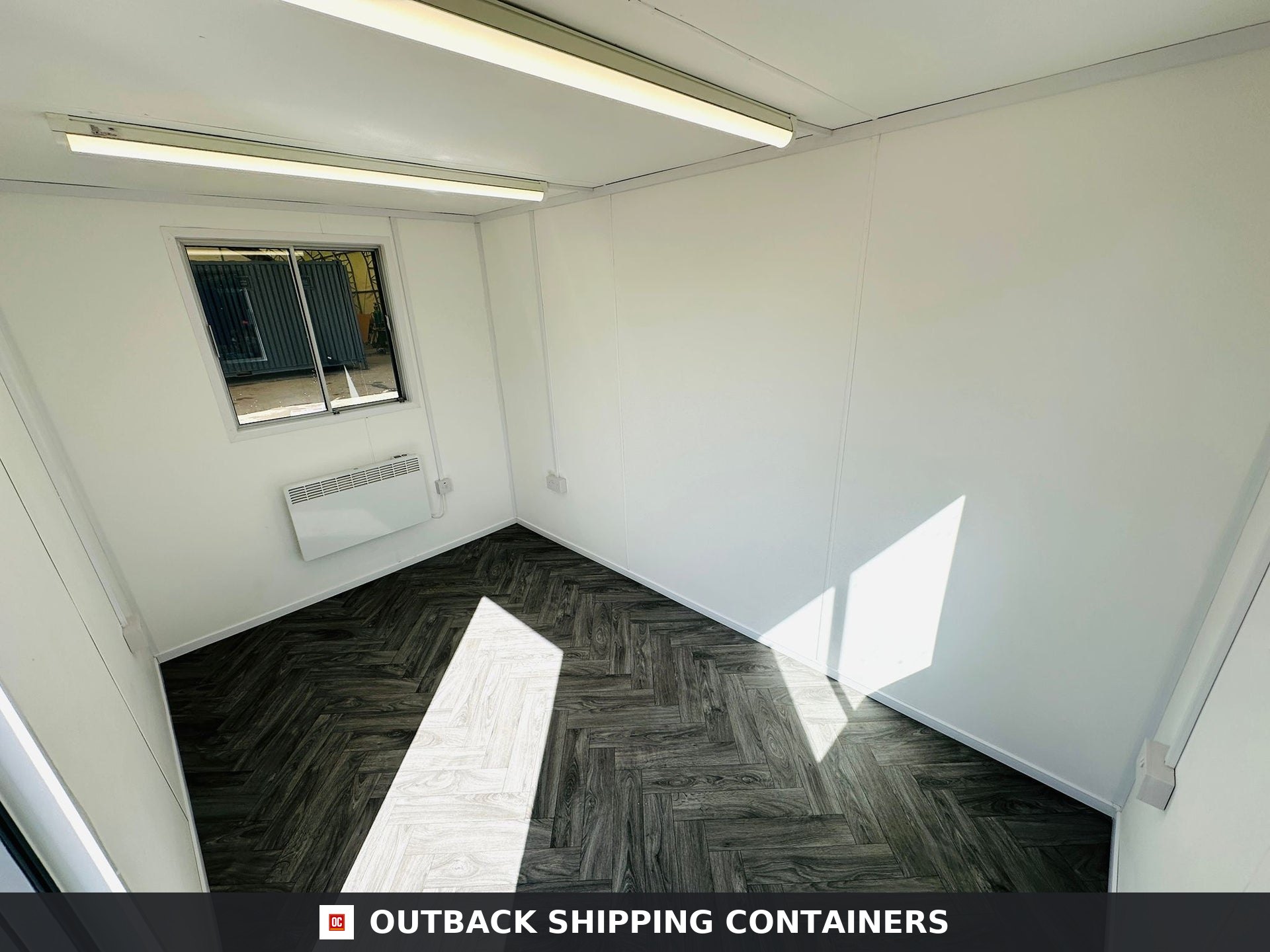 12x8 ft 12x8FT for Sale — Interior View | Outback Shipping Containers Gray 12x8 portable canteen building with anti-vandal window shutters and secure steel door against a blue sky