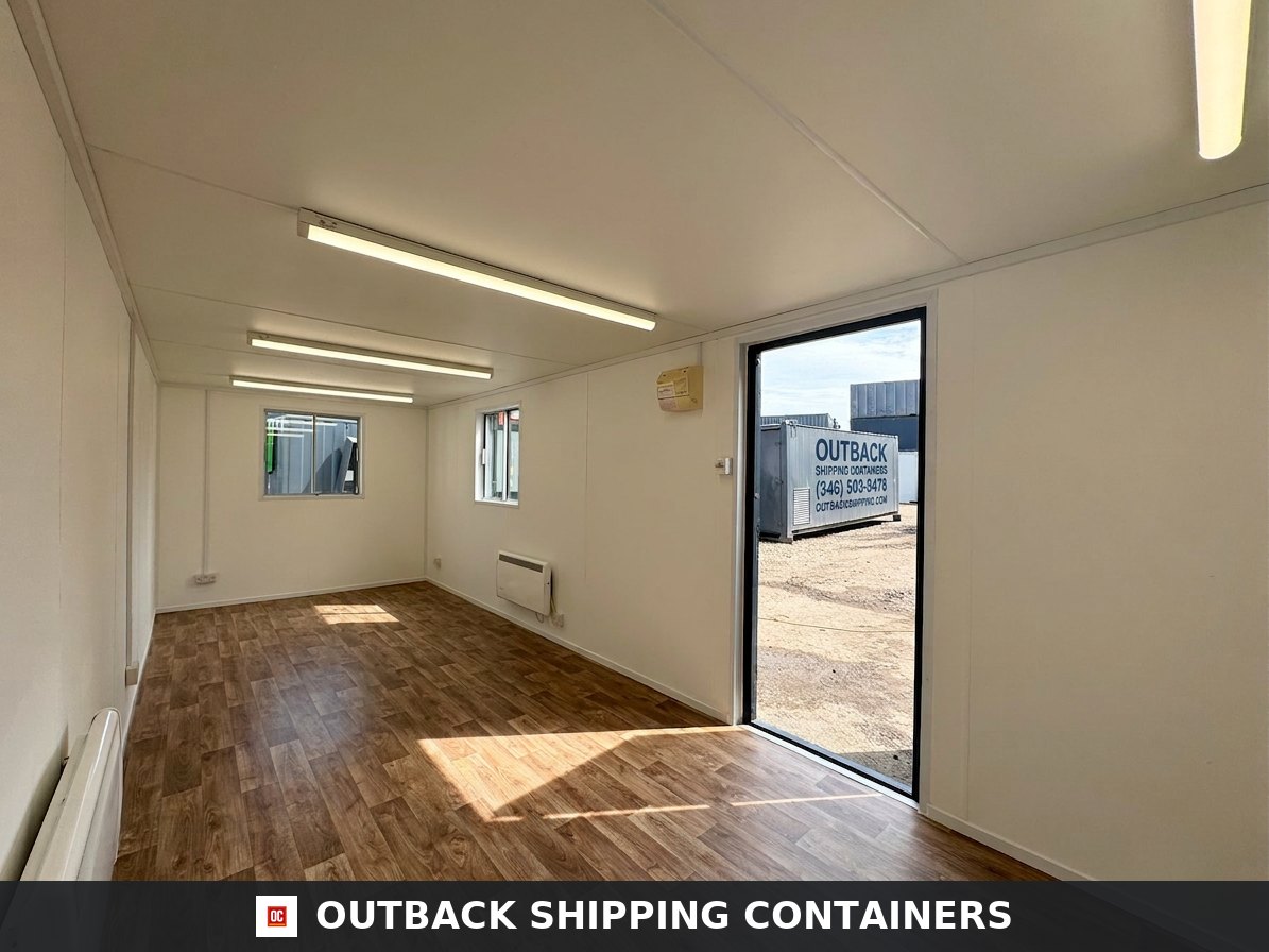 24x9 ft 24x9FT for Sale — Side Profile View | Outback Shipping Containers Interior view of a 24x9 open plan office cabin with wood vinyl flooring white walls and overhead LED tube lighting