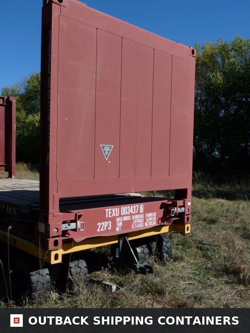 20FT flat rack shipping container with fixed end wall mounted on a yellow transport trailer in a grassy field