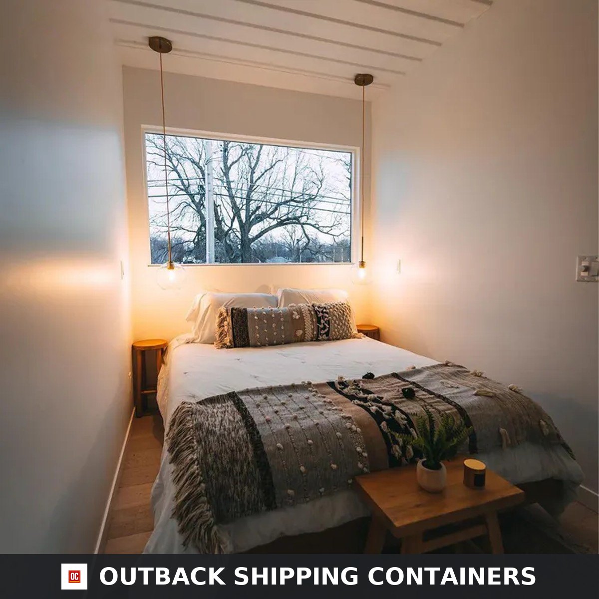 Ground floor bedroom of the Duplex 3BHK container home with queen bed, picture window and pendant lighting