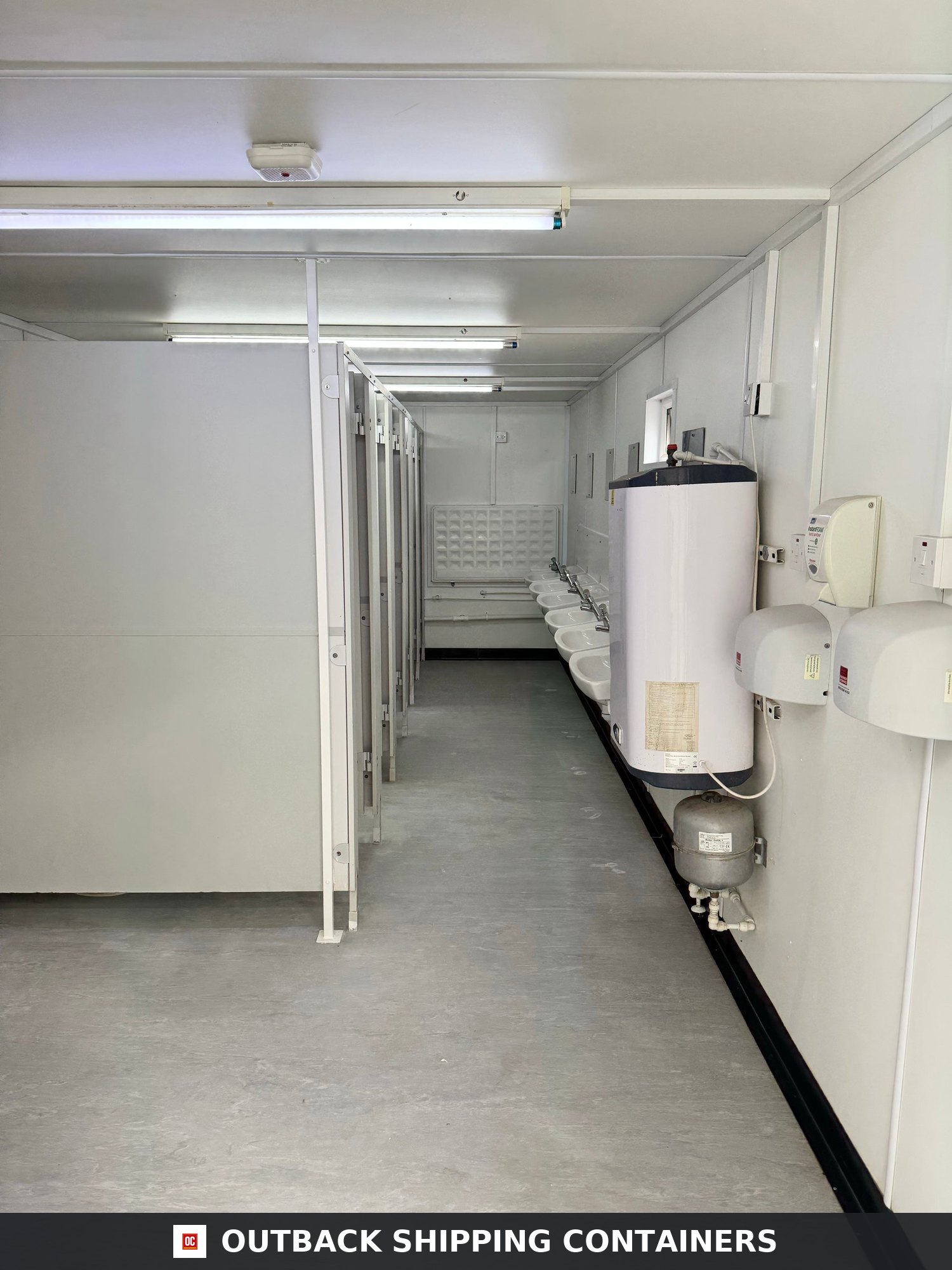 21x8ft for Sale — Interior Detail | Outback Shipping Containers Interior view of site accommodation toilets and washroom with sinks, stalls, and a large water heater
