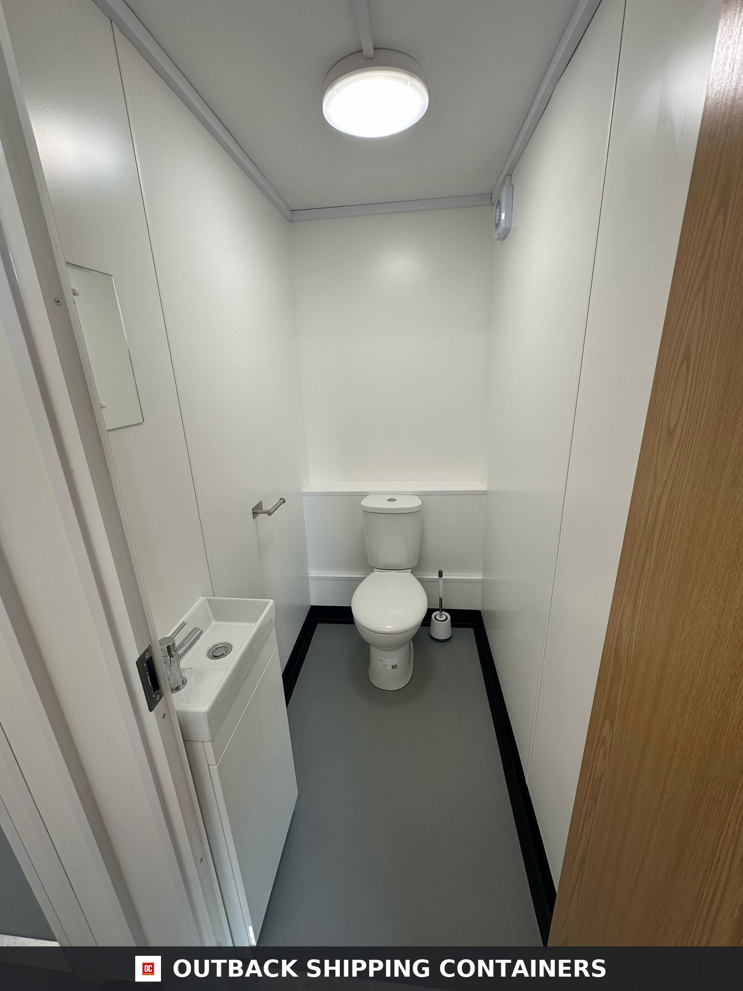 40x8ft for Sale — Roof and Structural Detail | Outback Shipping Containers 2 Interior view of a shipping container bathroom conversion featuring a white toilet, small sink, and neutral grey floor