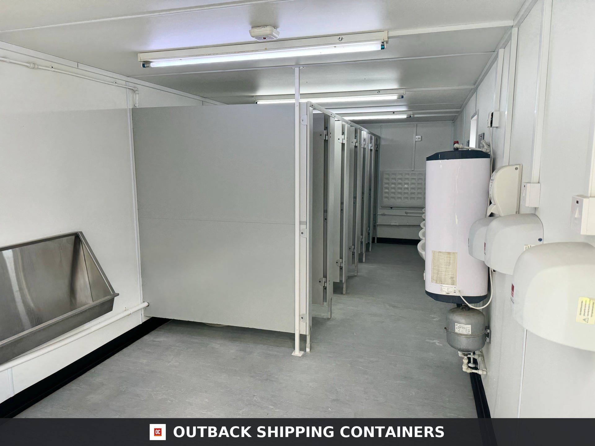 21x8ft for Sale — Interior View | Outback Shipping Containers Interior of 21ft site accommodation unit containing a stainless steel urinal and multiple private toilet stalls