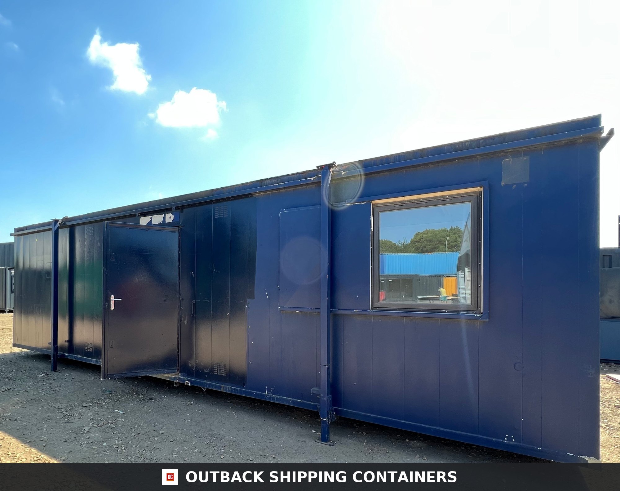24x9 ft 24X9FT for Sale — Door and Entry Detail | Outback Shipping Containers Blue 24x9 ft anti-vandal shipping container office cabin with open door and secure window set against a blue sky