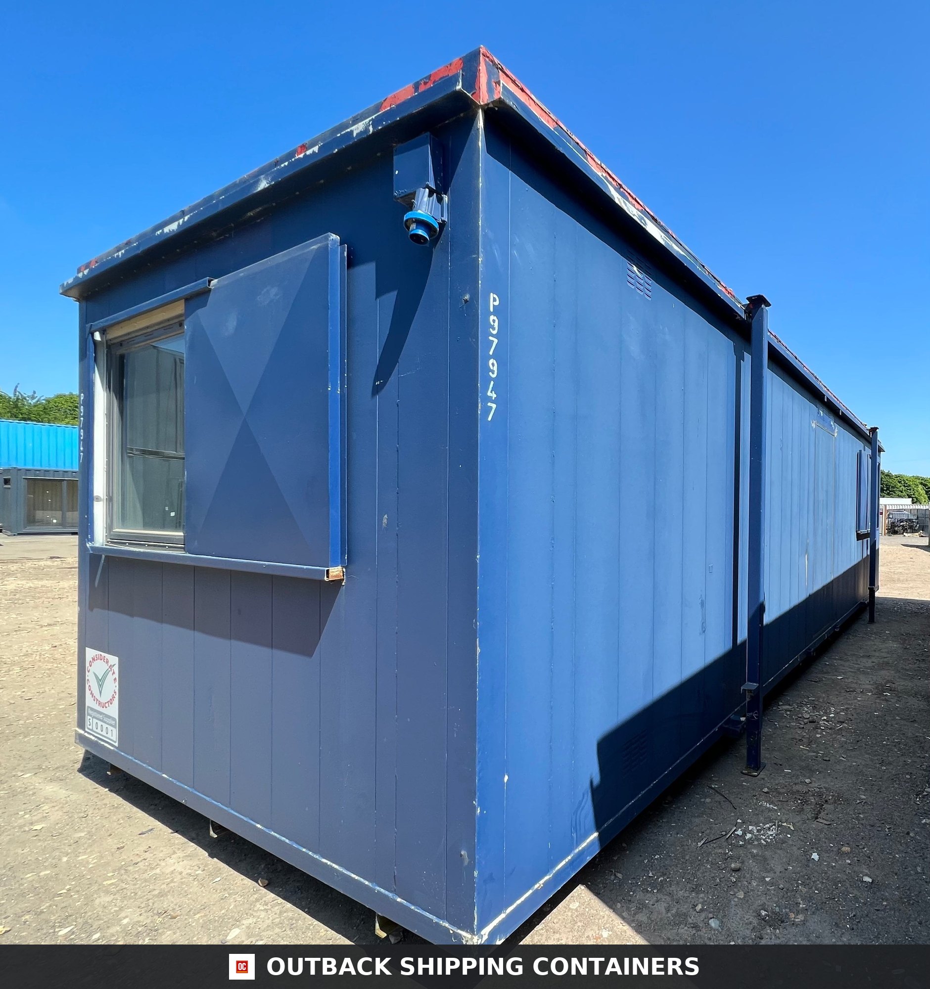 Refurbished 24x9 ft anti-vandal portable office cabin in blue with steel window shutters and side profile
