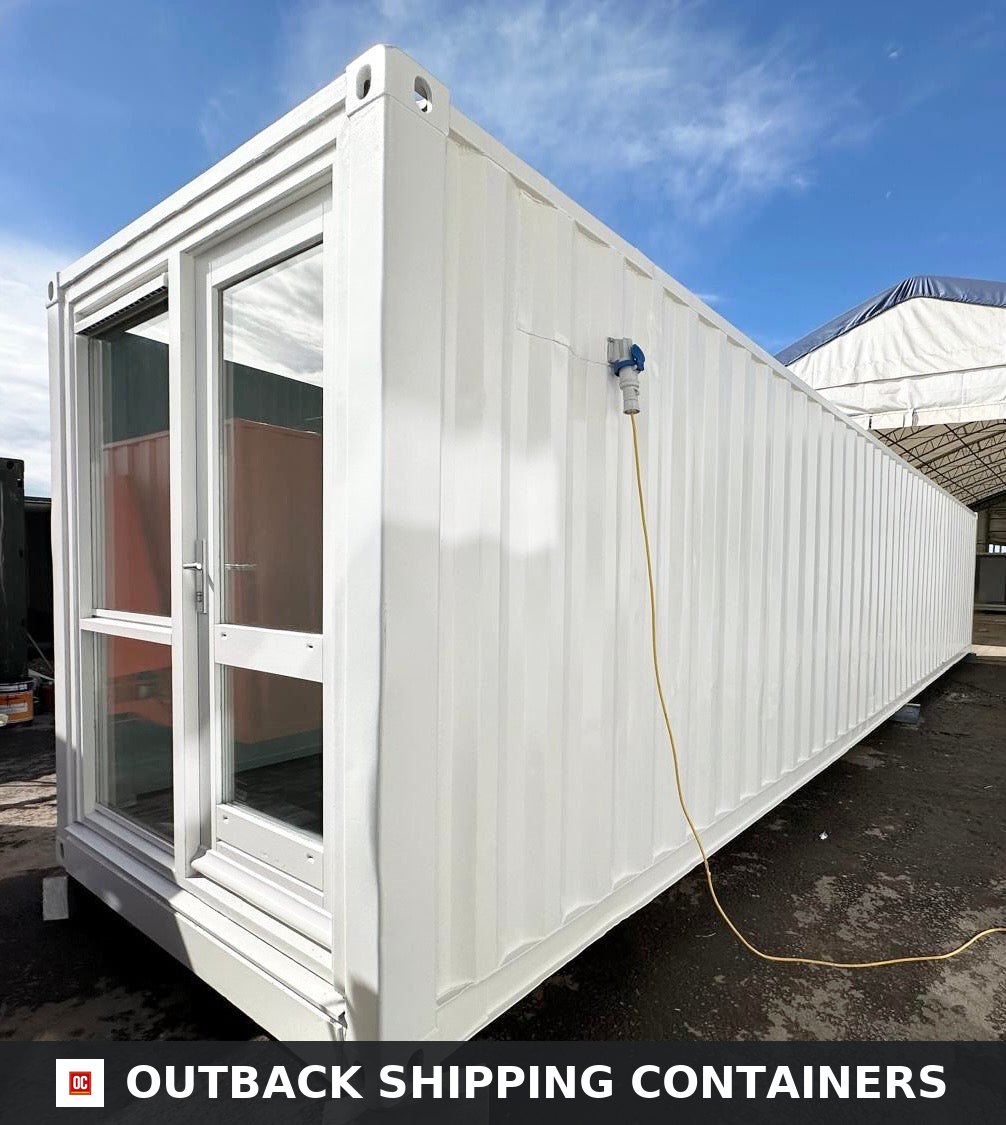 40ft white shipping container office with glass double doors and external power inlet under a bright blue sky