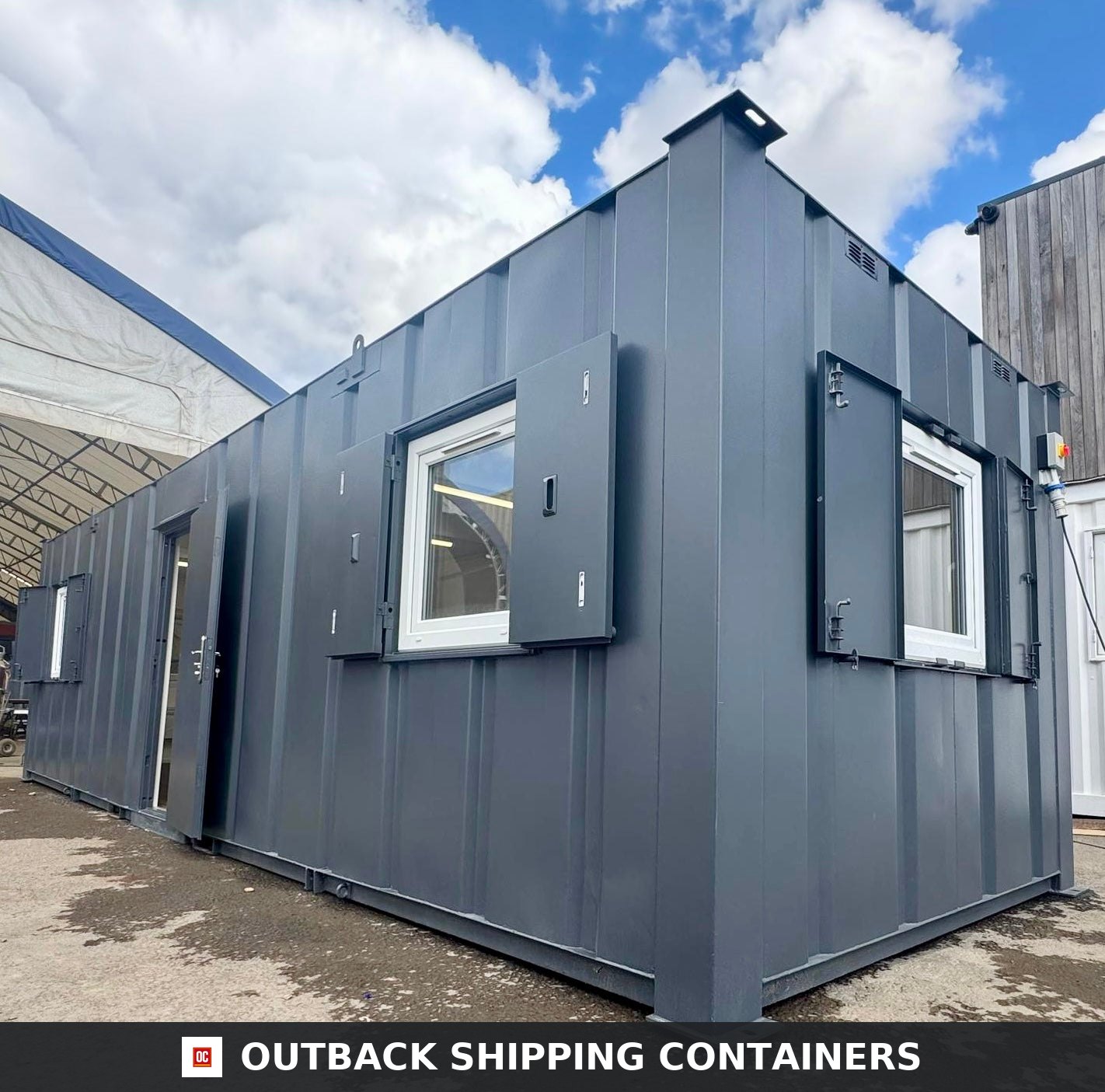32ft Cabin for Sale — Three-Quarter Angle View | Outback Shipping Containers Refurbished 32ft anti-vandal portable cabin in dark gray with open steel shutters and white framed windows