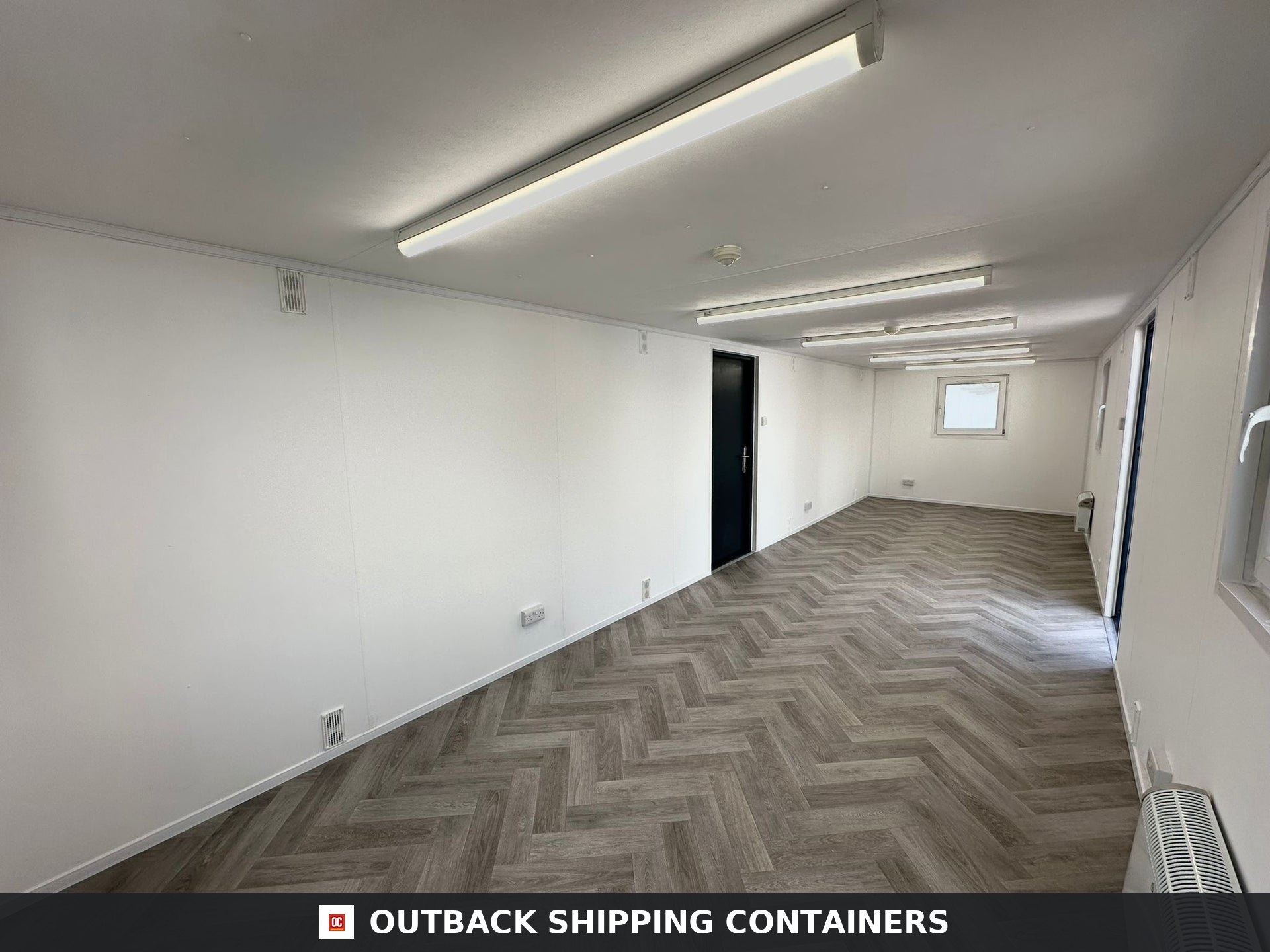 32x10ft Cabin for Sale — Window and Shutter Detail | Outback Shipping Containers 2 Interior view of a 32x10ft container office featuring white walls and herringbone pattern flooring